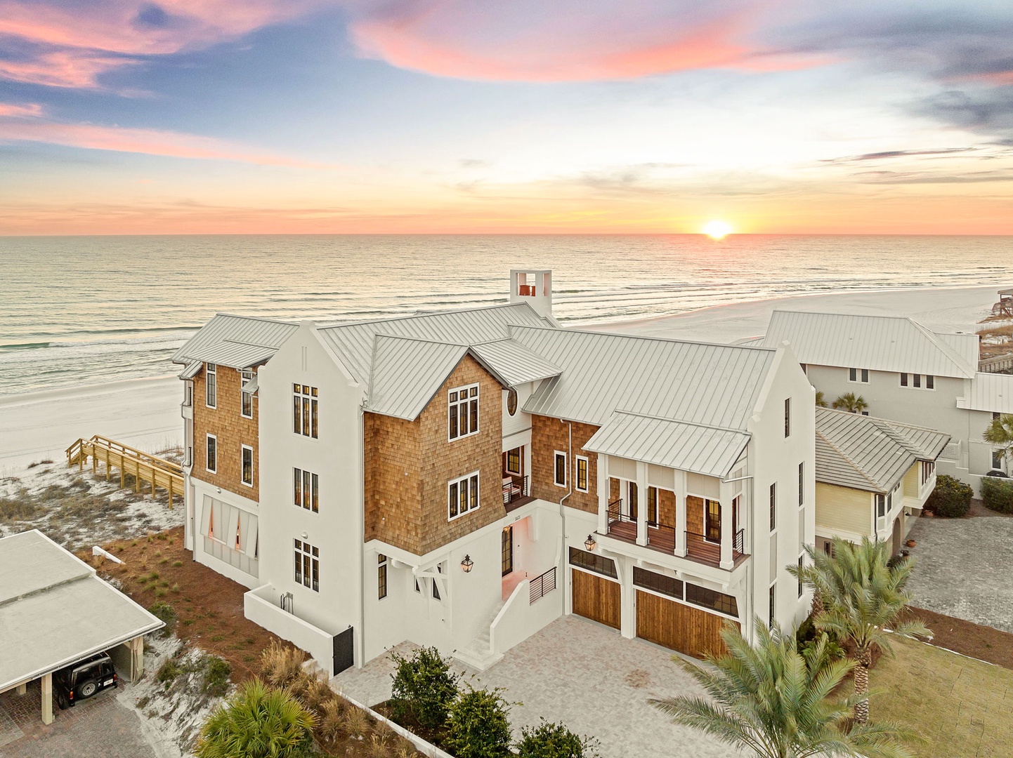 Stunning beachfront property showcasing modern coastal architecture with dramatic sunset views over the Gulf waters.