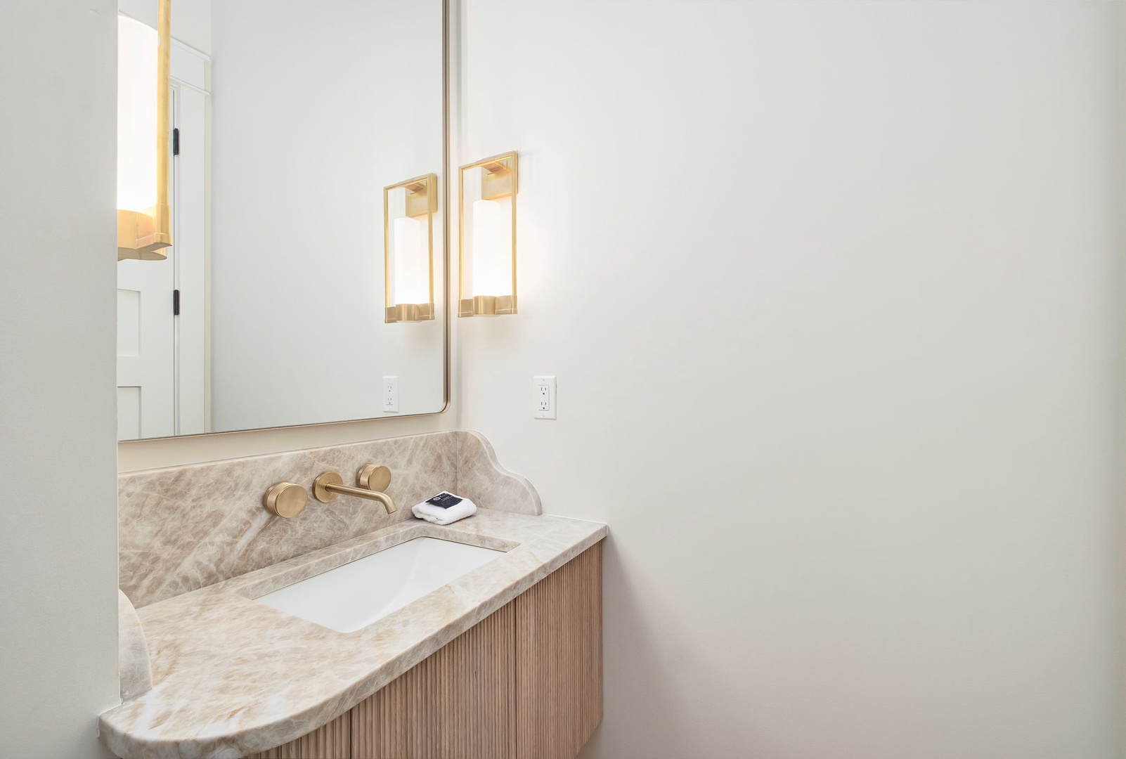 Freshen up in your elegantly designed bathroom, featuring a beautiful marble vanity and warm brass fixtures that add a touch of sophistication to your daily routine.