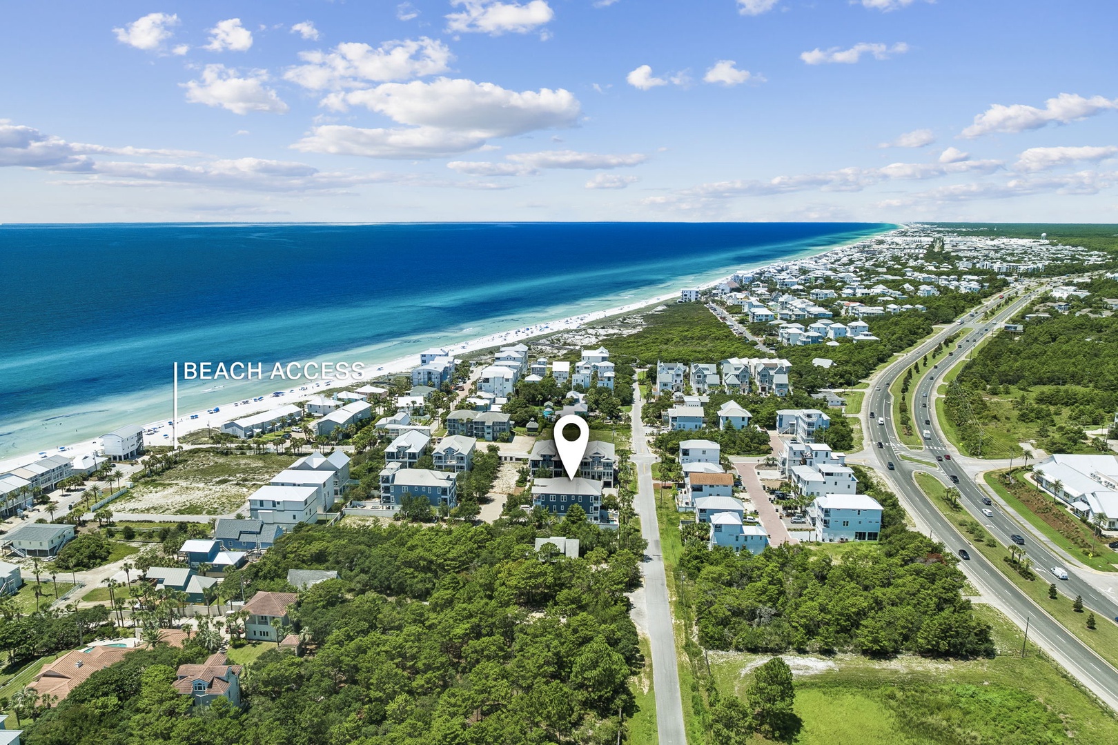 An aerial view of a coastal neighborhood showcasing the property's prime location near pristine white-sand beaches and turquoise waters, with convenient beach access just steps away.