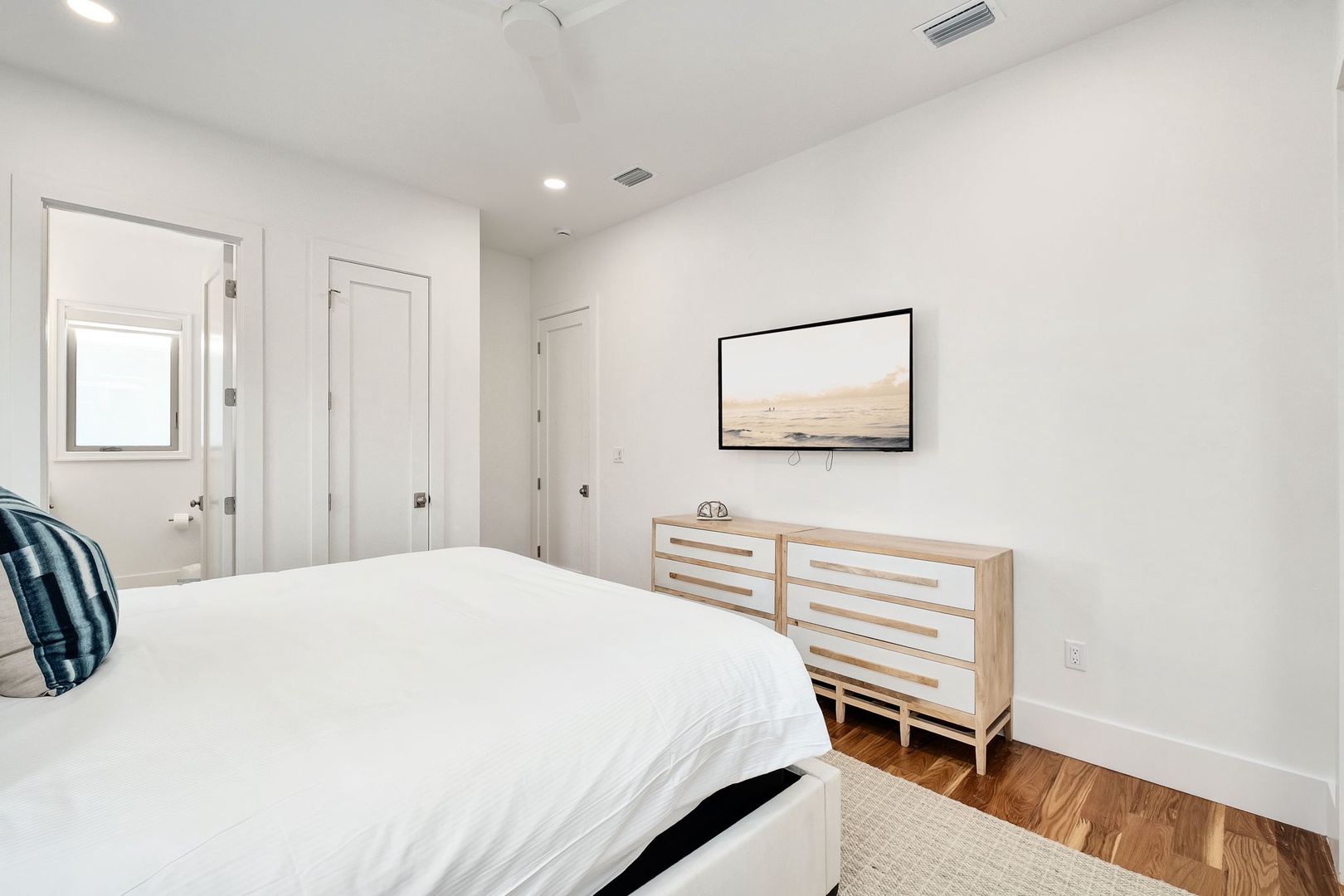 Your peaceful bedroom features a cozy bed, stylish dresser, and wall-mounted TV for relaxing evenings after exploring the area.