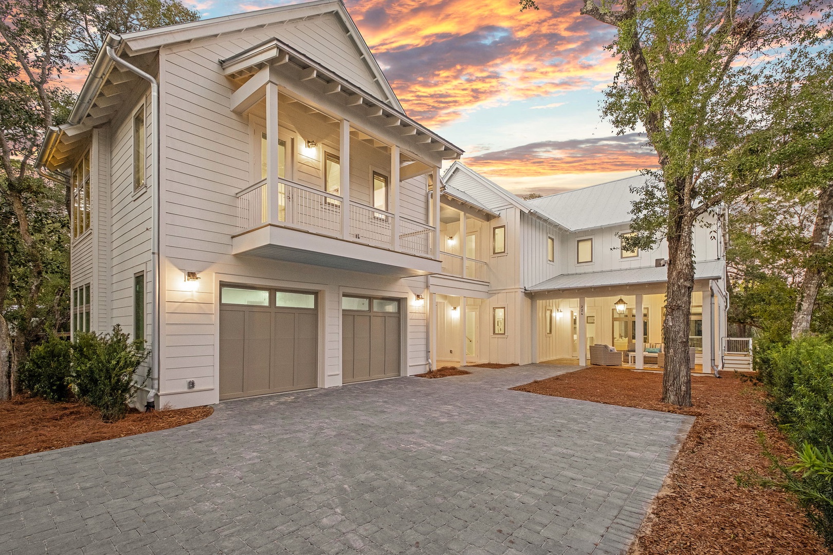 Beautiful modern coastal home with dramatic sunset sky creating a stunning arrival experience for your vacation getaway.