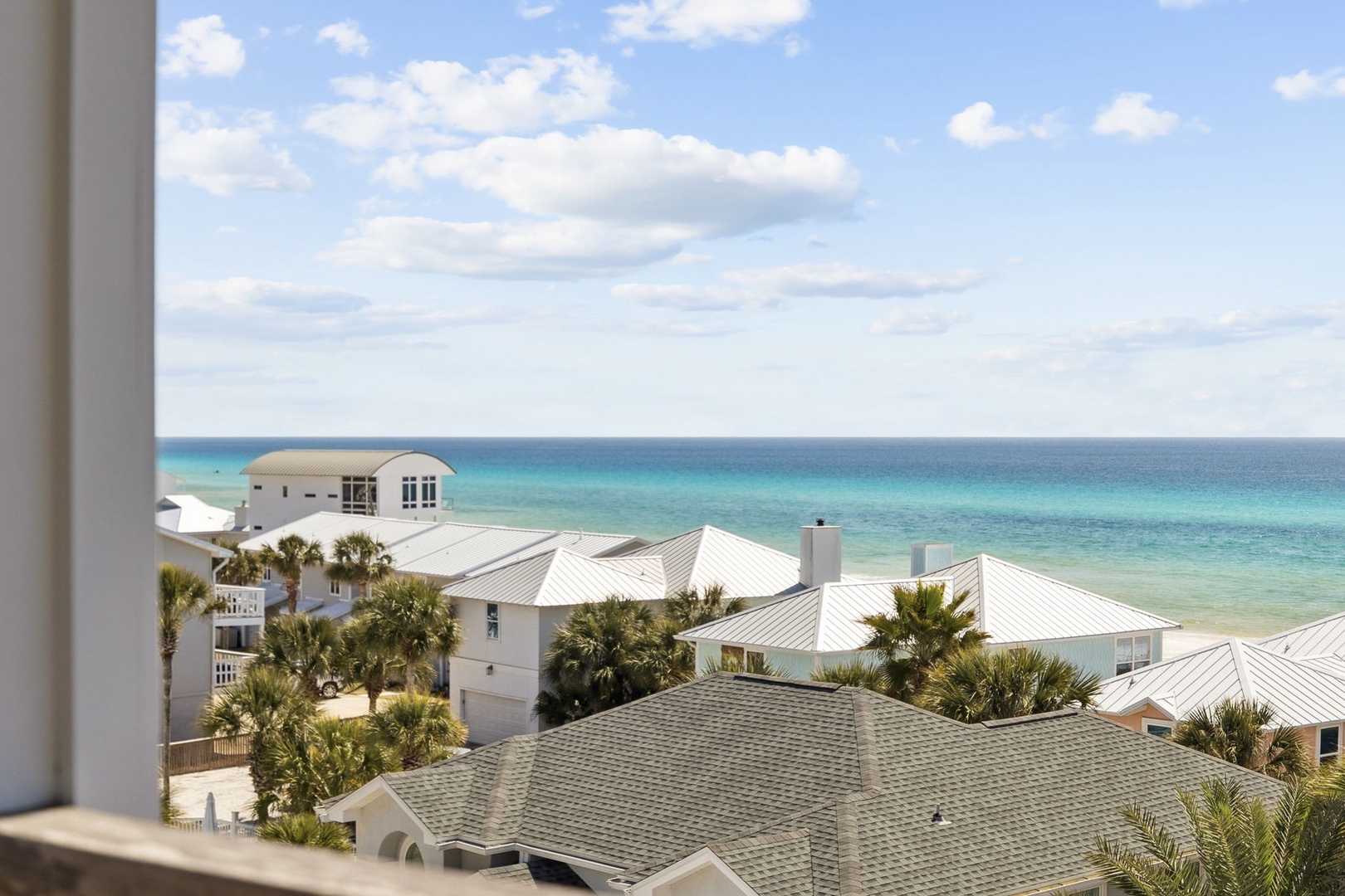 Stunning oceanfront panorama from your window showcasing pristine turquoise waters and coastal architecture below.