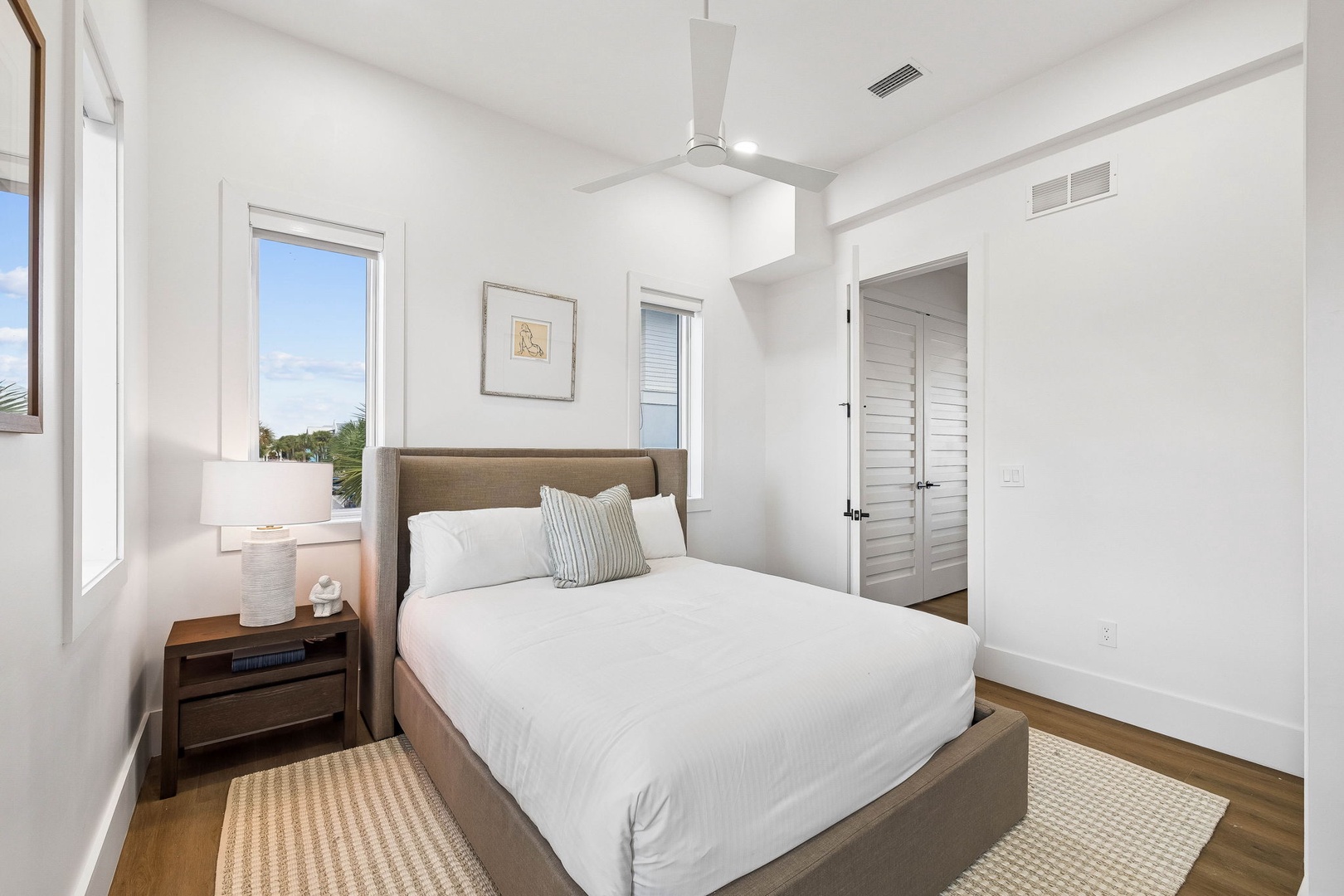 Drift off in this peaceful bedroom with crisp linens, calming neutral tones, and tall ceilings that keep your space open and airy. Wake to natural light streaming through the windows.