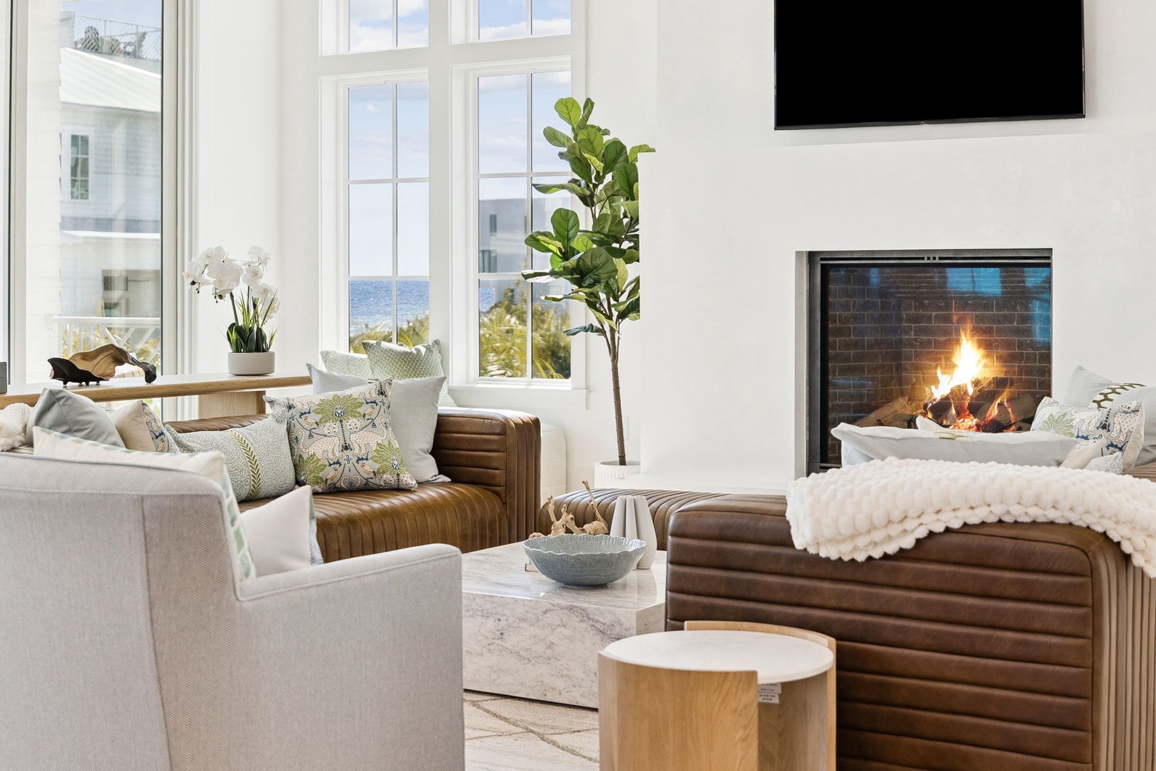 Unwind by your private fireplace in this bright, elegant living space with cozy seating and stunning natural light streaming through oversized windows.