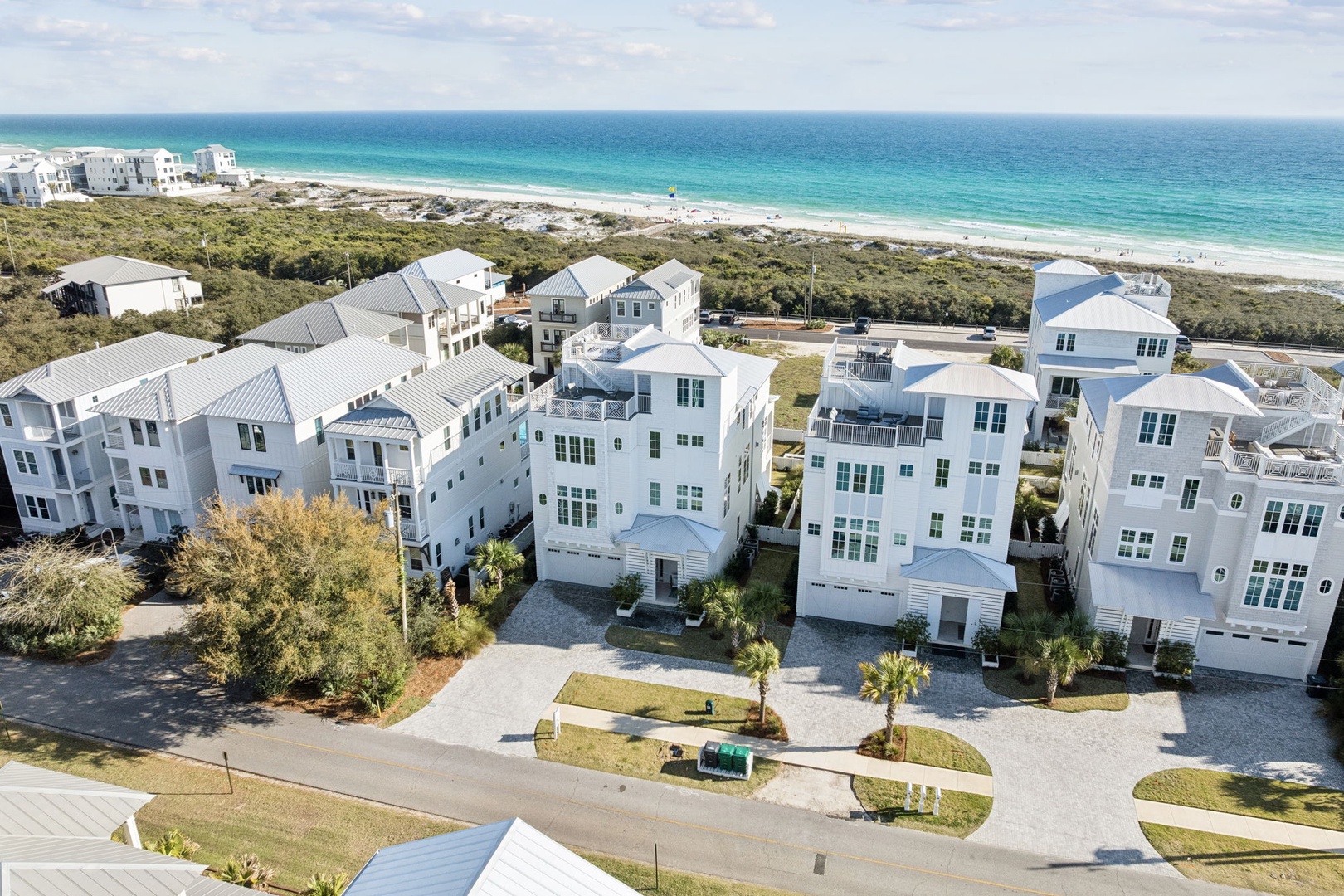 Stunning beachfront community with modern coastal homes overlooking pristine white sand beaches and turquoise waters.