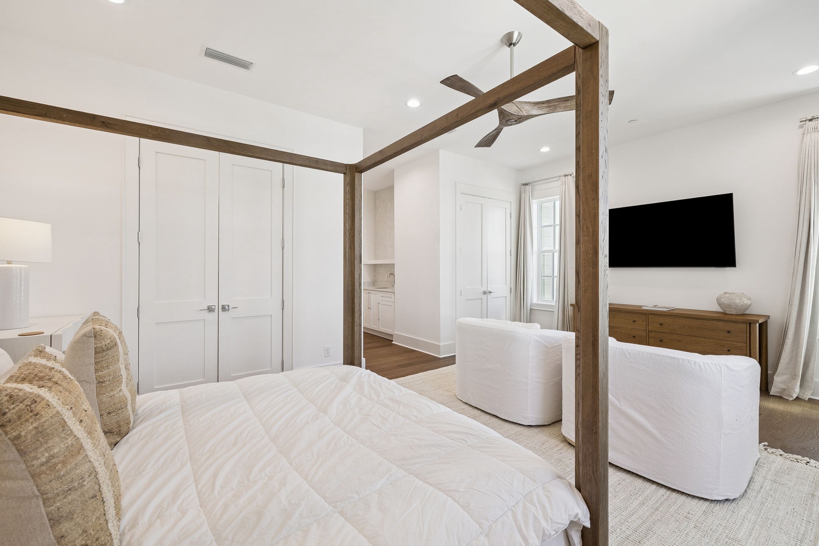 Unwind in your elegant master suite featuring a striking four-poster bed, cozy seating area, and spa-like ensuite.