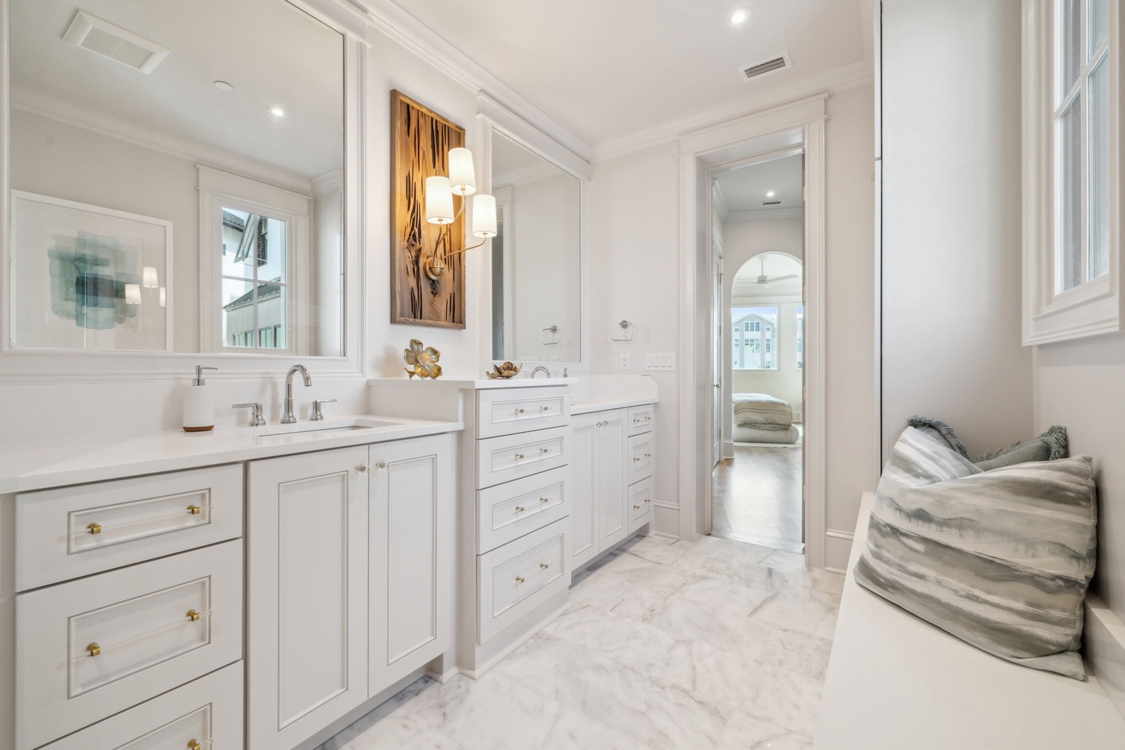 Your luxurious ensuite features dual vanities with elegant marble countertops, soft ambient lighting, and a stylish seating nook—perfect for your morning routine in refined comfort.