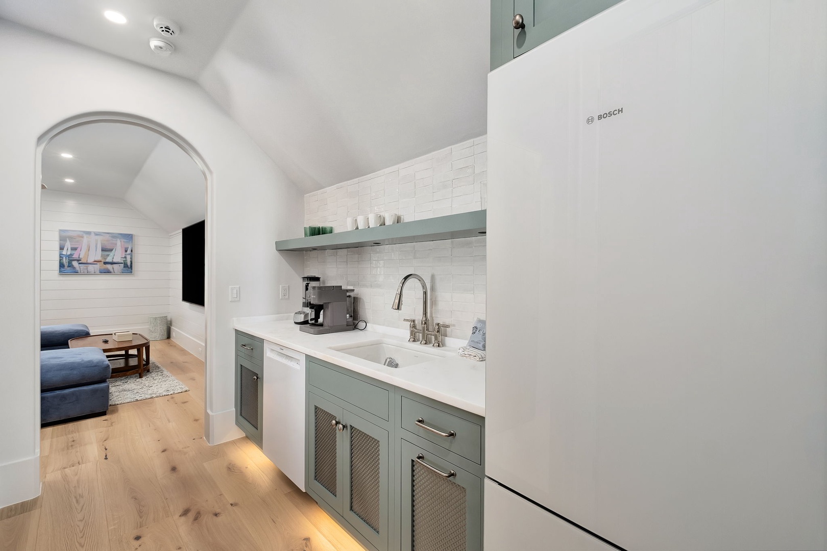 Your stylish kitchen features sage cabinets, white quartz counters, and quality Bosch appliances, perfect for preparing meals.