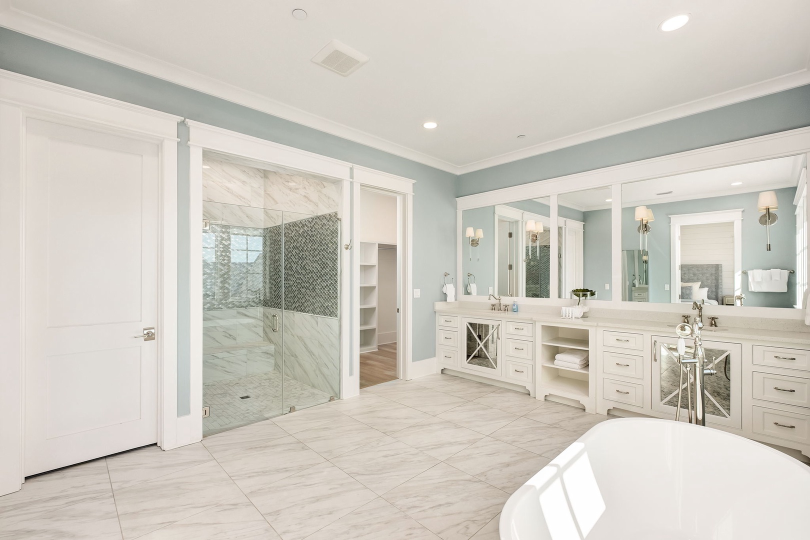 Luxurious master bathroom with elegant dual vanities, spacious glass shower, and soothing coastal colors for your ultimate relaxation.