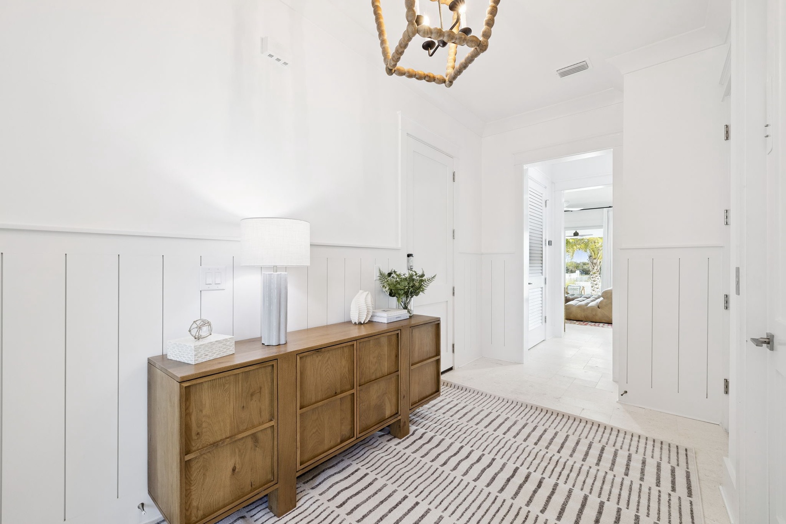 Step into your bright, airy entryway where warm wood tones meet crisp white walls, creating an instantly welcoming first impression.