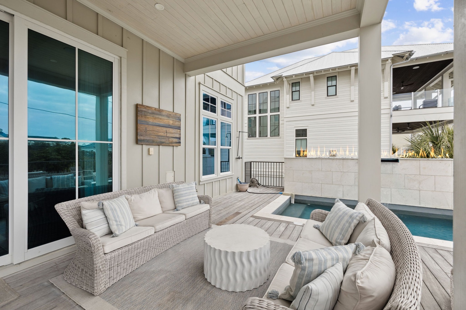 Unwind in your private covered patio with plush seating overlooking the sparkling pool—perfect for morning coffee or evening relaxation.