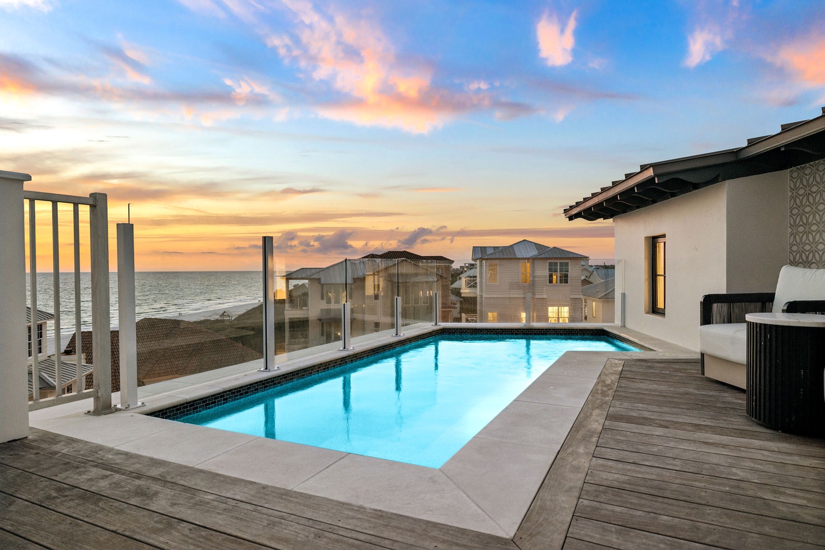 A stunning beachfront retreat with a private pool overlooking the ocean at sunset—a serene setting for a memorable coastal getaway.