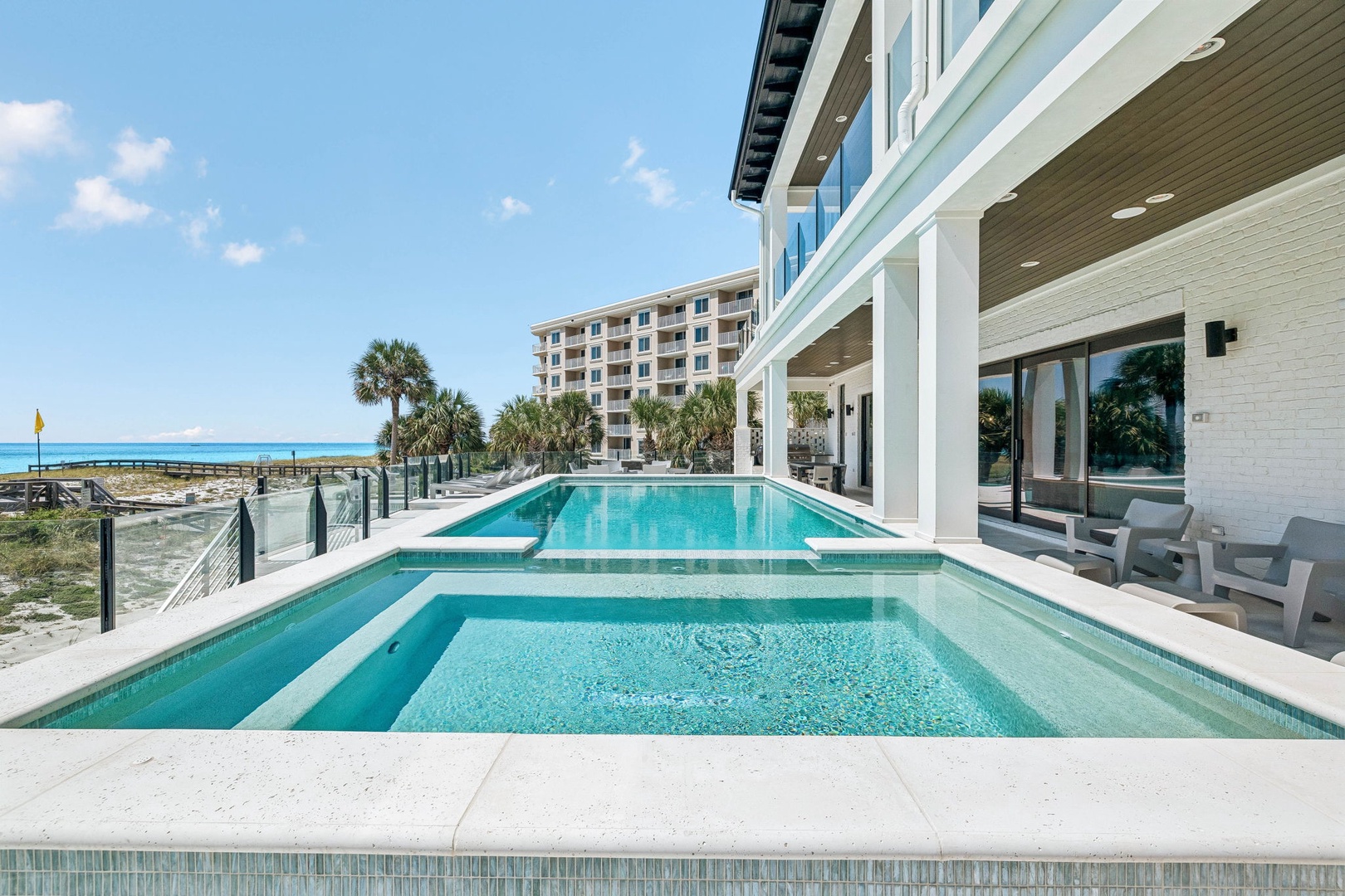 Two sparkling pools meet white sand and ocean beyond—an effortless morning routine awaits you here, steps from your private beach access.