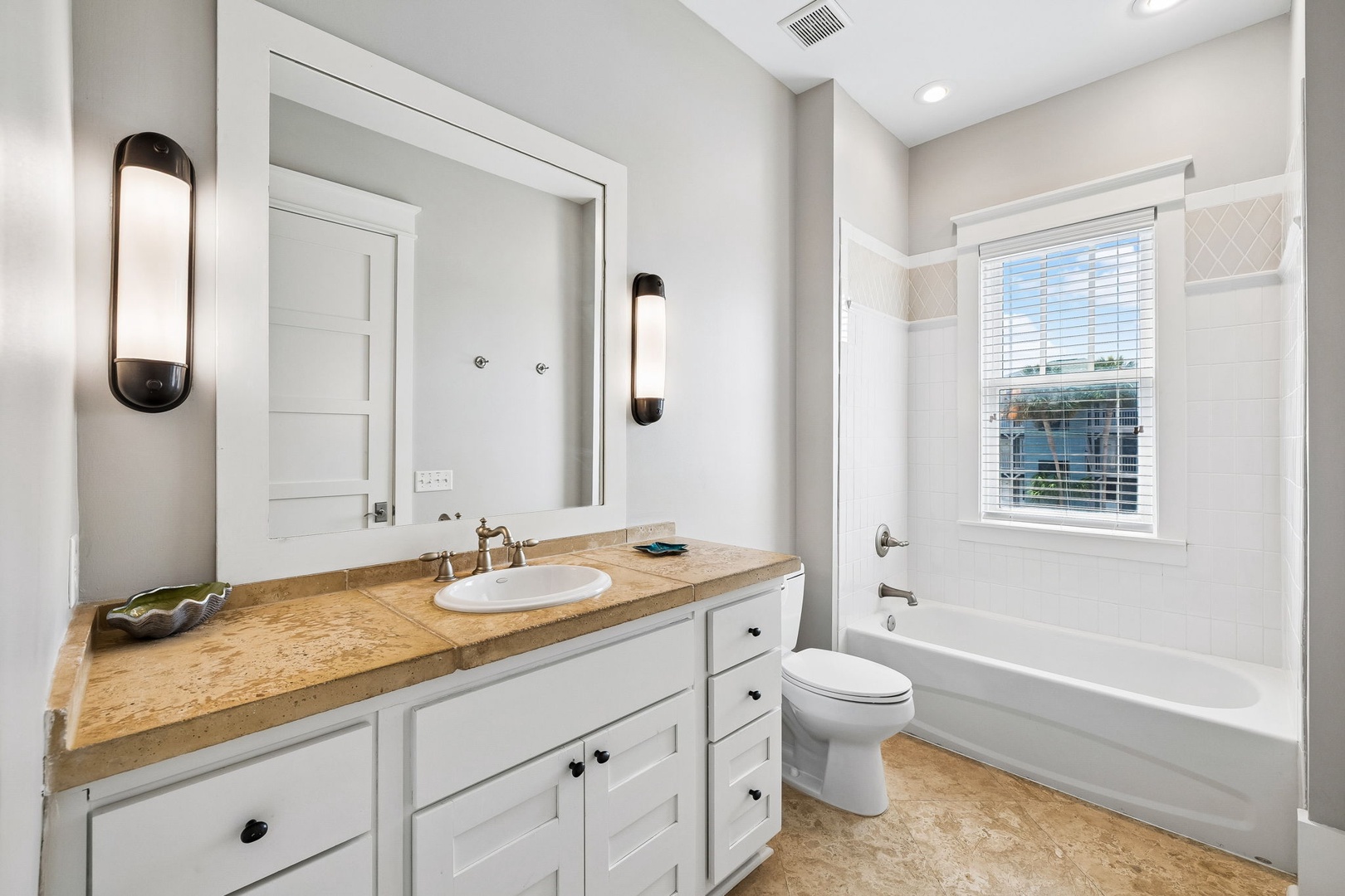 Freshen up in your stylish bathroom with warm wood tones and bright natural light. You'll appreciate the spacious vanity, soaking tub, and elegant sconce lighting.