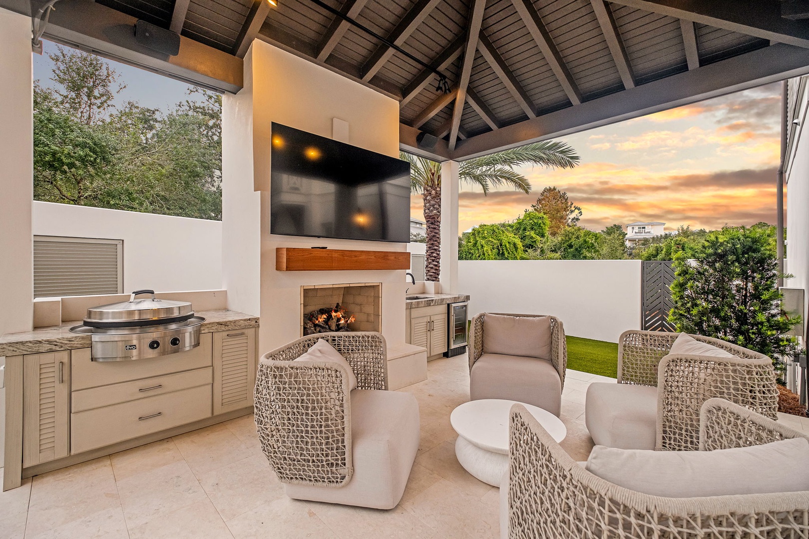 Gather around your covered outdoor living space, complete with a built-in grill, fireplace, and cozy seating—perfect for entertaining or unwinding in the warm evening air.