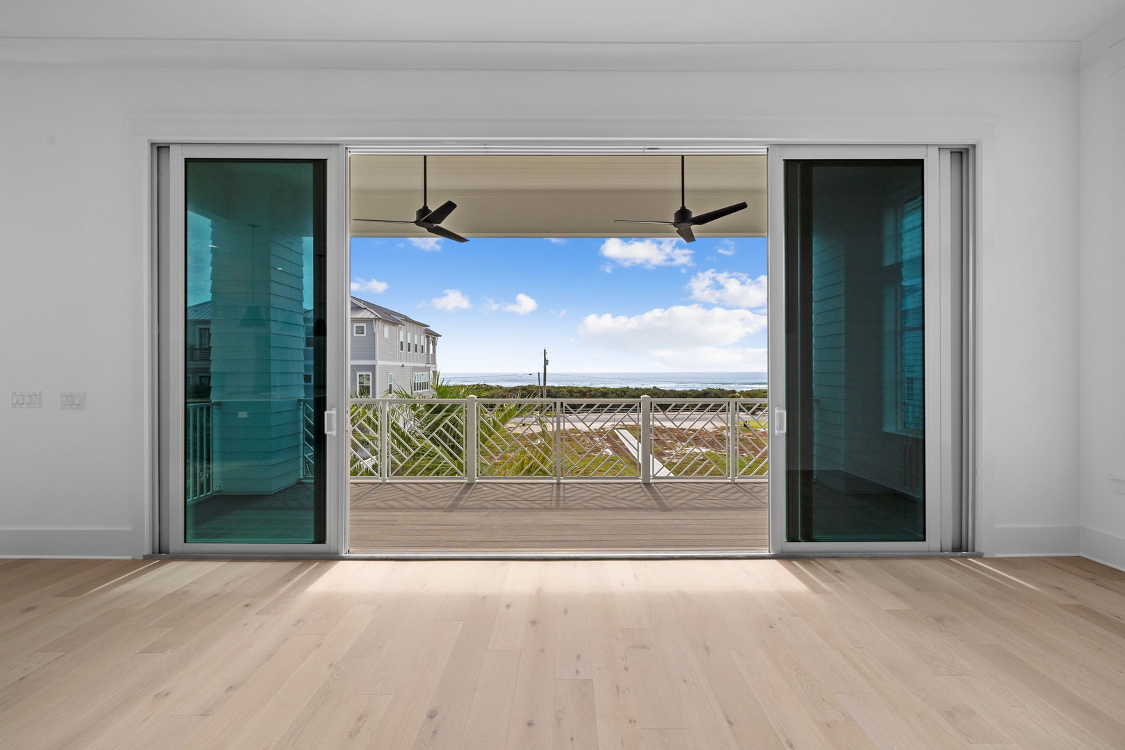 Step into your bright living space where floor-to-ceiling windows frame stunning marsh views and open onto your private deck.