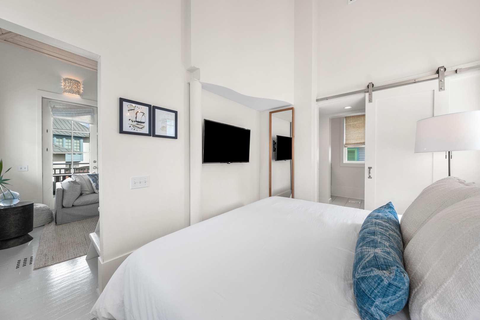 Sink into crisp white bedding and let the modern coastal charm wrap around you in this beautifully designed bedroom retreat.