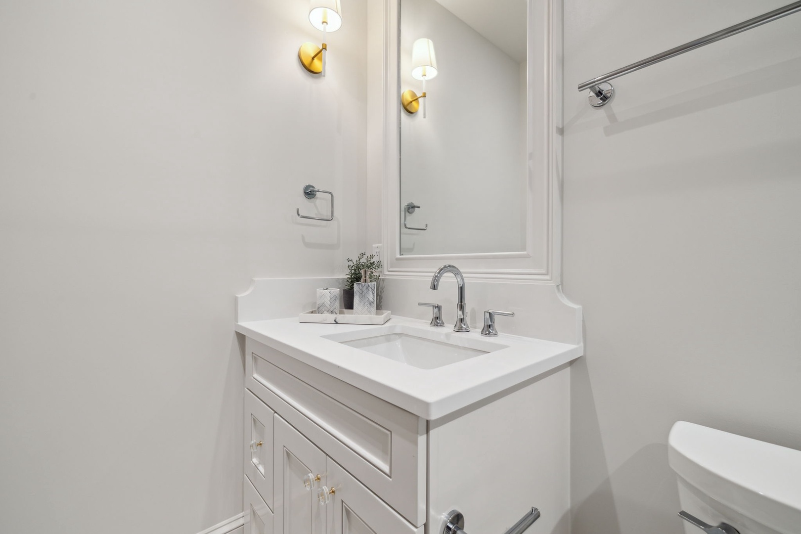 Your pristine bathroom offers a peaceful retreat with elegant brass lighting, a spacious vanity, and a refreshing walk-in shower—perfect for unwinding after your adventures.