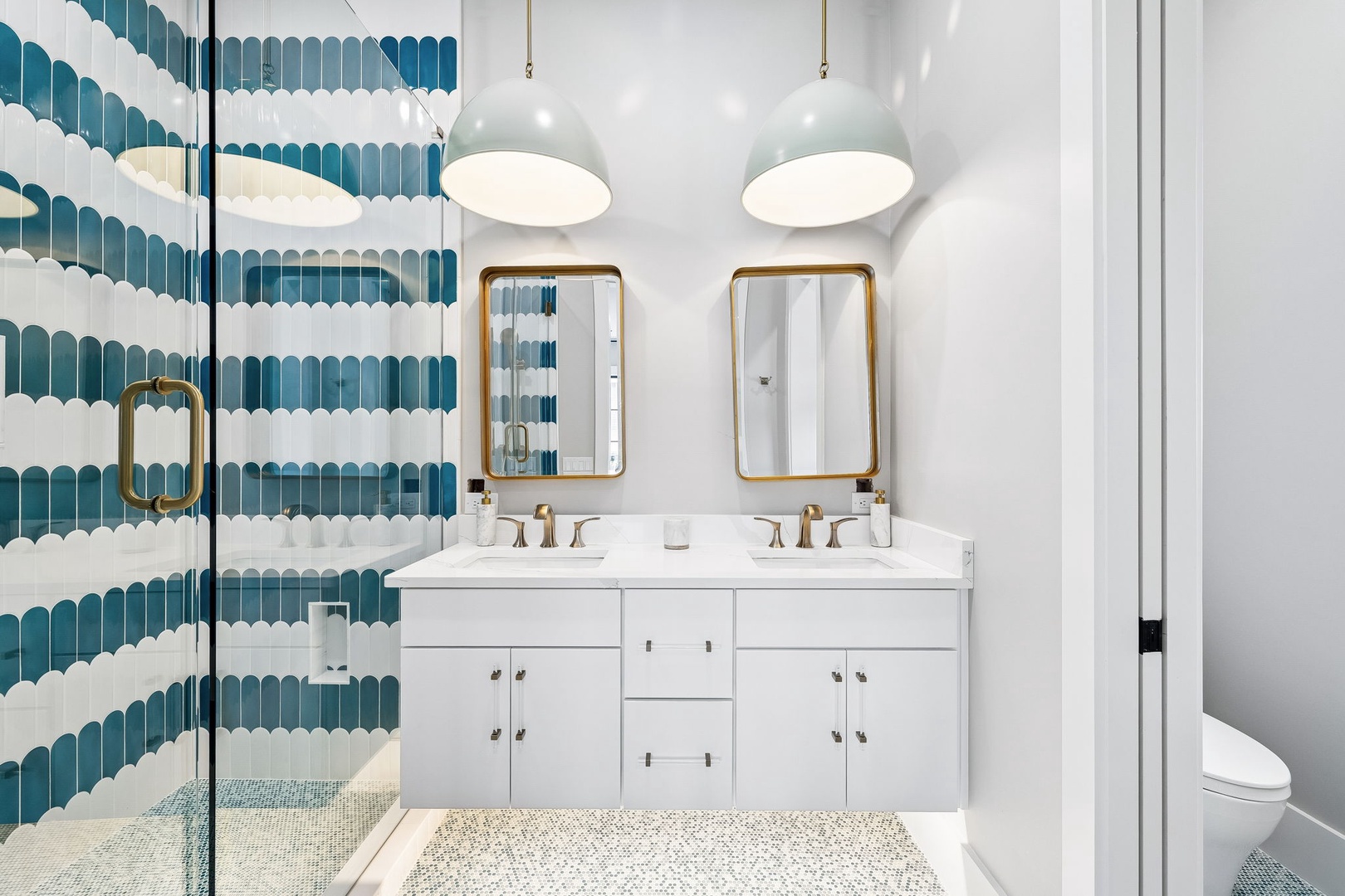 Step into your own coastal oasis. Gorgeous wave-patterned tiles and warm brass accents make freshening up feel like a spa retreat.