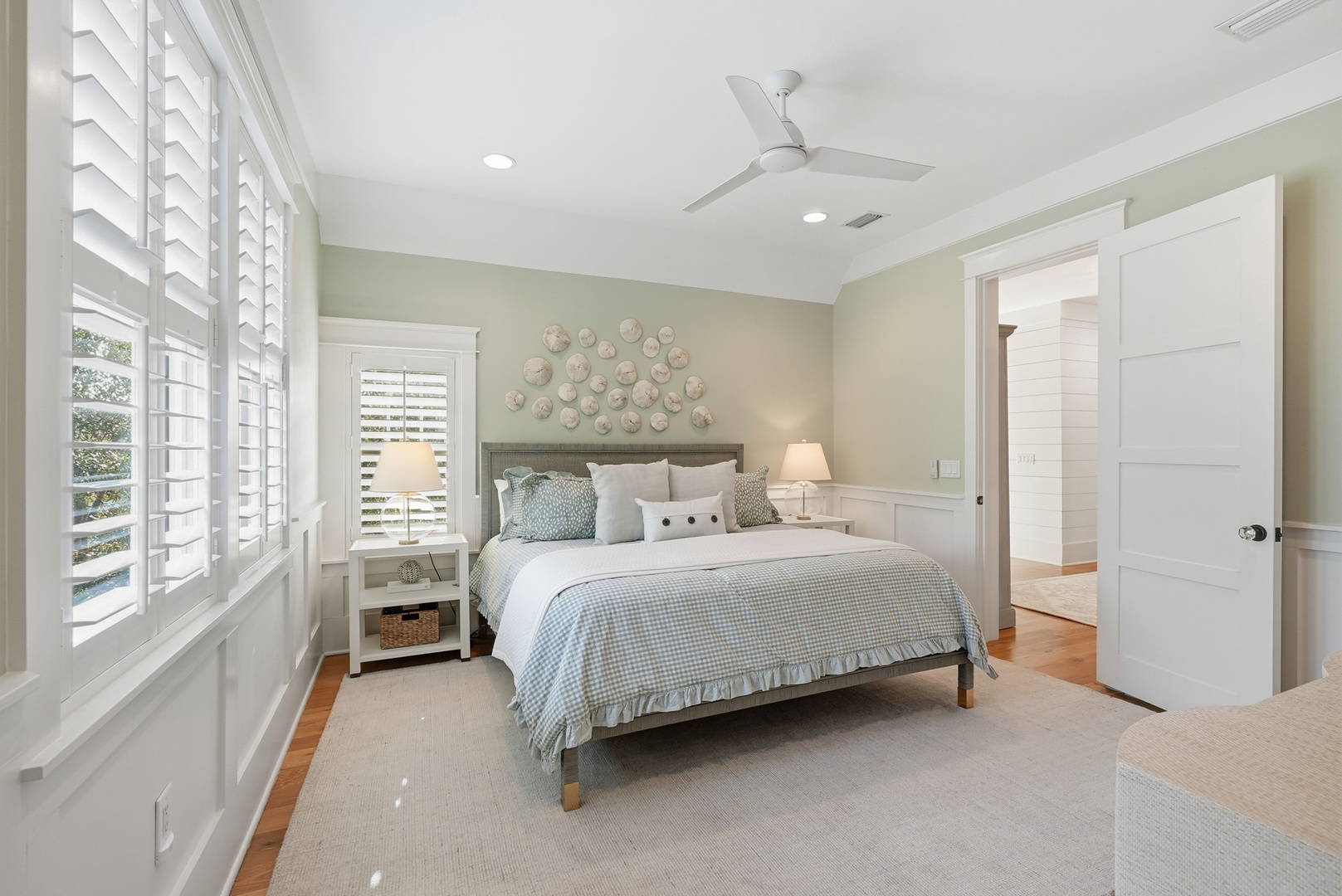 Sink into peaceful sleep in your coastal-inspired bedroom with calming sea-green tones, soft linens, and gentle breezes from the ceiling fan overhead.
