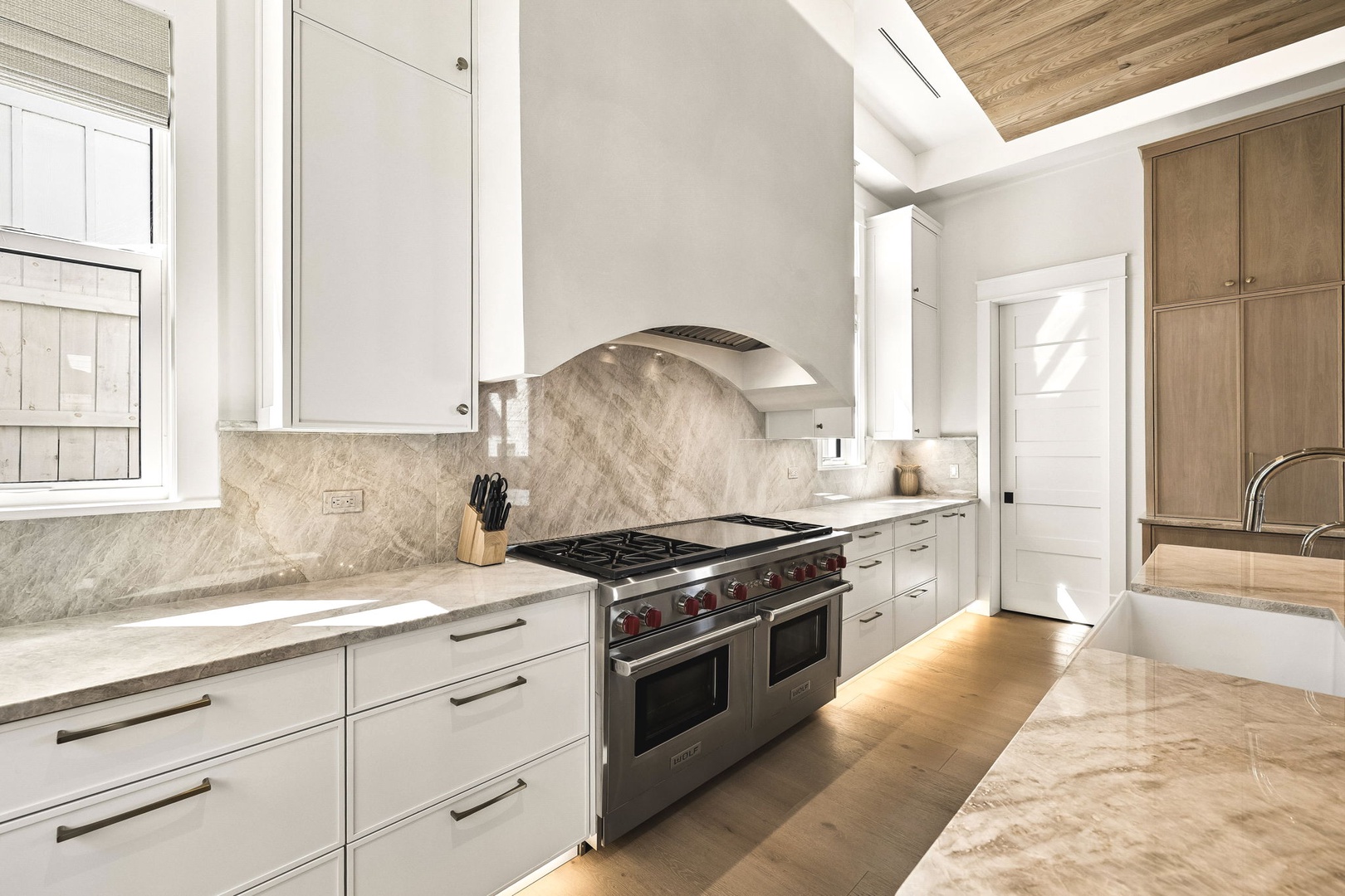 Step into a chef's dream kitchen with gleaming marble countertops, professional-grade appliances, and warm wood accents that invite you to create memorable meals in style.