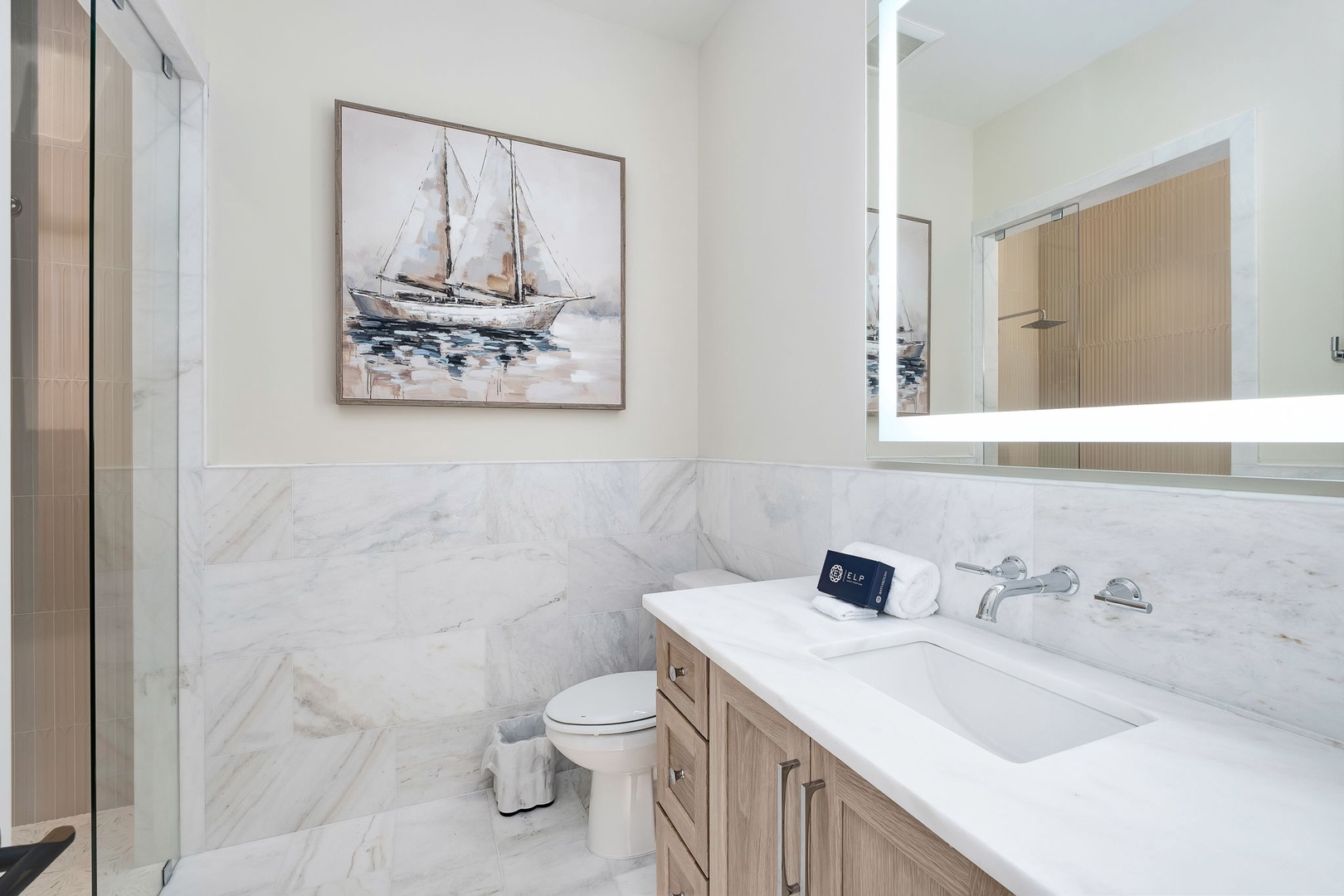 Step into your private marble bathroom, where soft coastal art and elegant finishes create a serene escape. Fresh towels and a sparkling vanity welcome you to unwind in style.