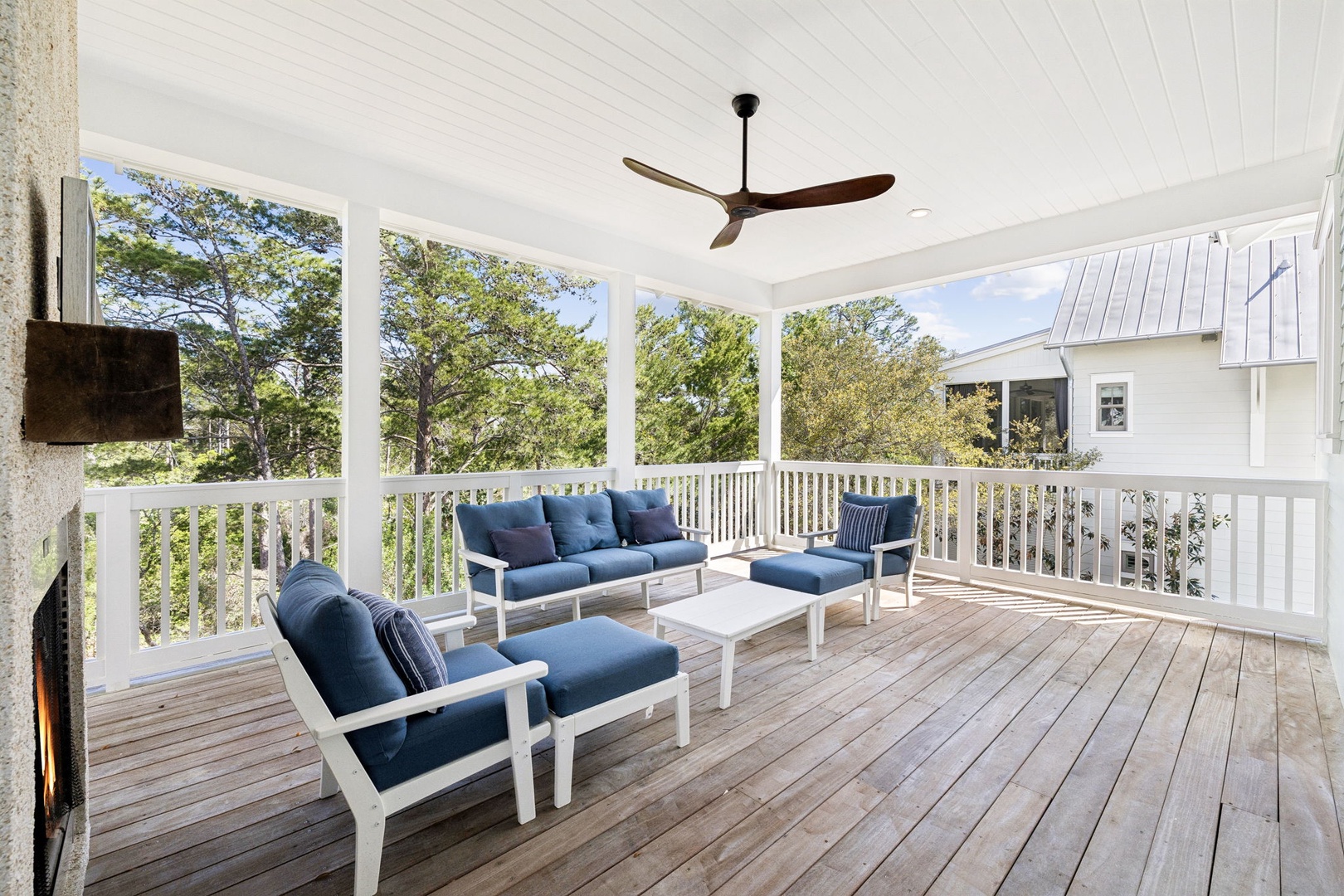 Unwind on your private covered porch with cozy blue seating and peaceful tree views—the perfect spot for morning coffee or evening relaxation.