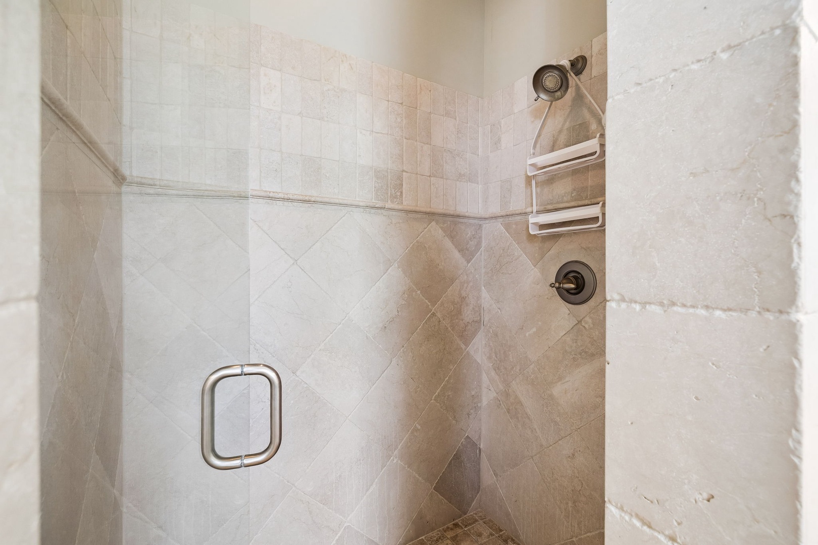 Rinse away the day in your spacious walk-in shower, thoughtfully designed with built-in shelving for your essentials and elegant tiled walls that create a spa-like retreat.