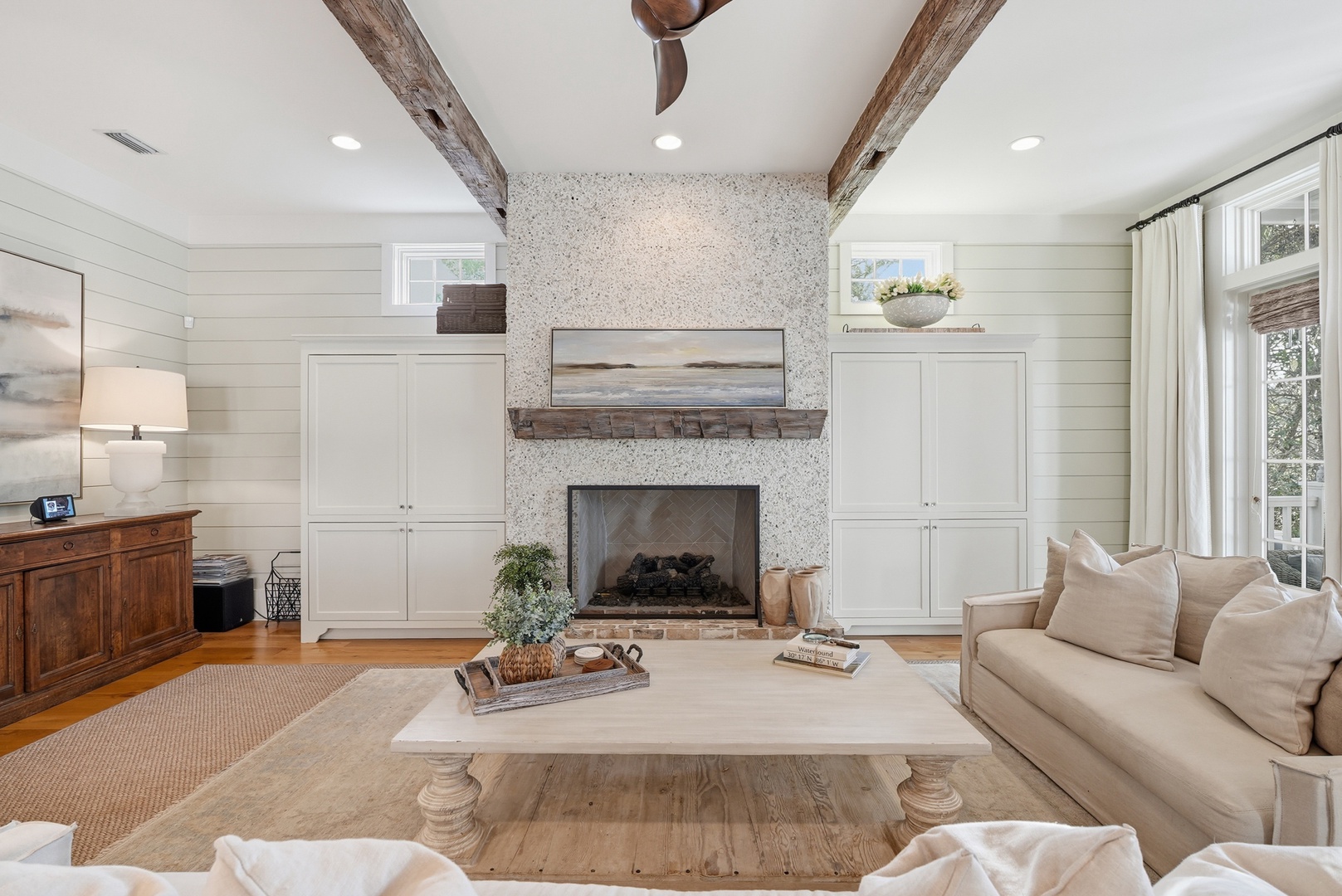 Sink into plush seating by the fireplace, where rustic wood beams meet coastal elegance. Your perfect retreat for unwinding after exploring the area.