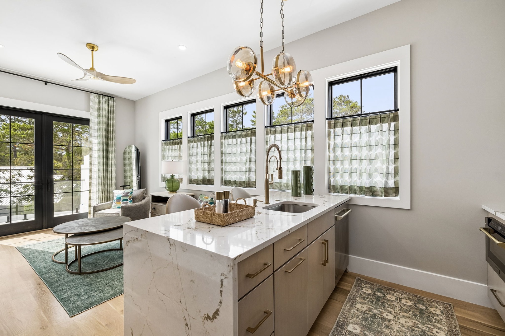 Your open-concept kitchen features elegant marble countertops, a spacious island, and abundant natural light streaming through multiple windows overlooking the serene surroundings.