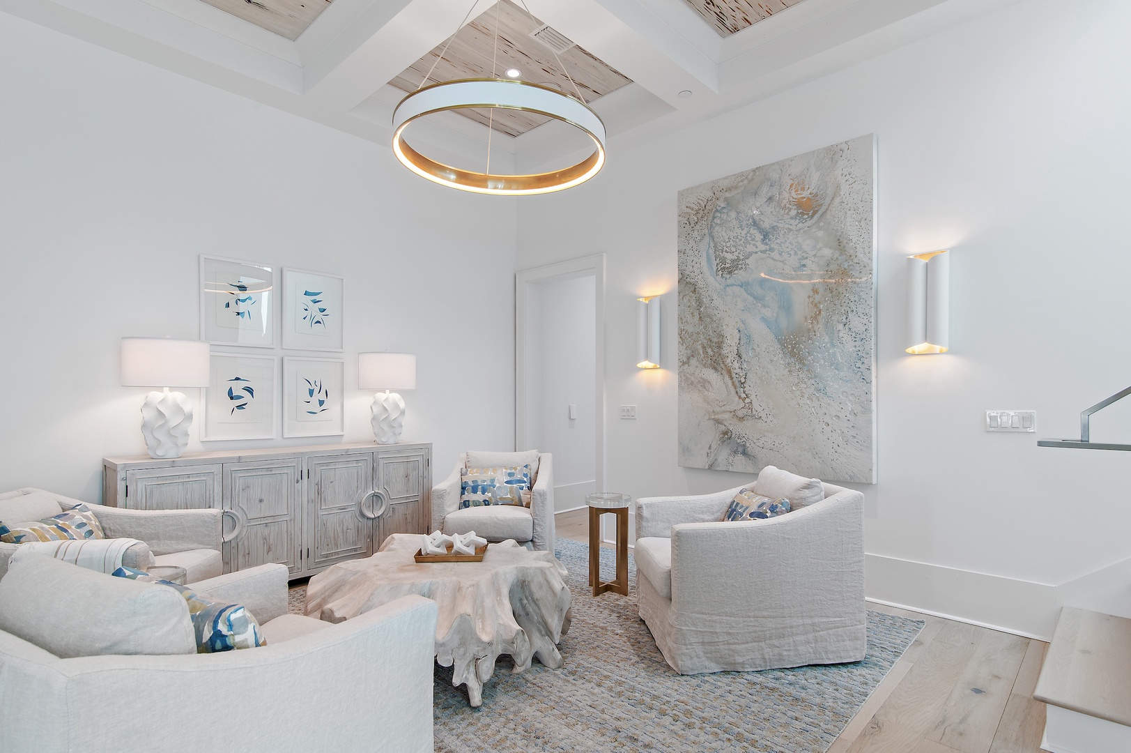 Sink into plush seating beneath soaring ceilings accented with weathered wood and a striking chandelier. This airy, coastal-inspired living space blends tranquility with refined style, perfect for relaxing after your day's adventures.