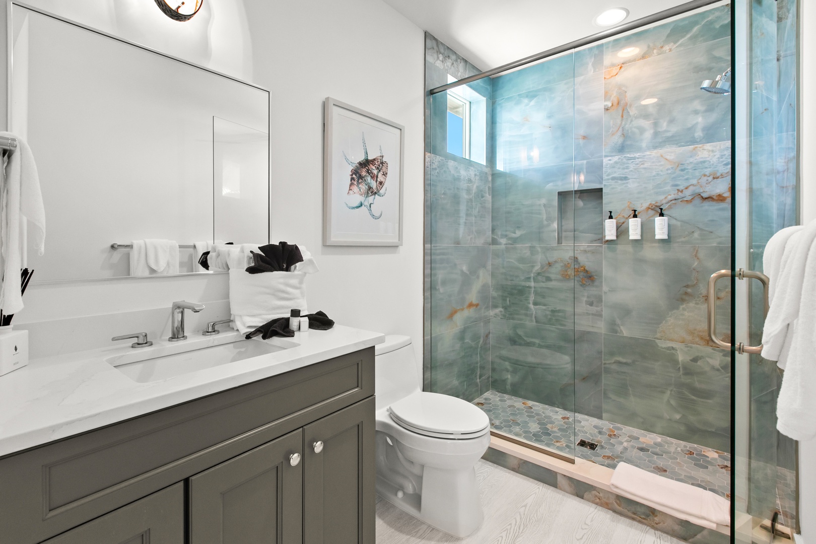 Step into your spa-like bathroom, featuring calming ocean-inspired tile and a walk-in glass shower that makes every day feel like a retreat.