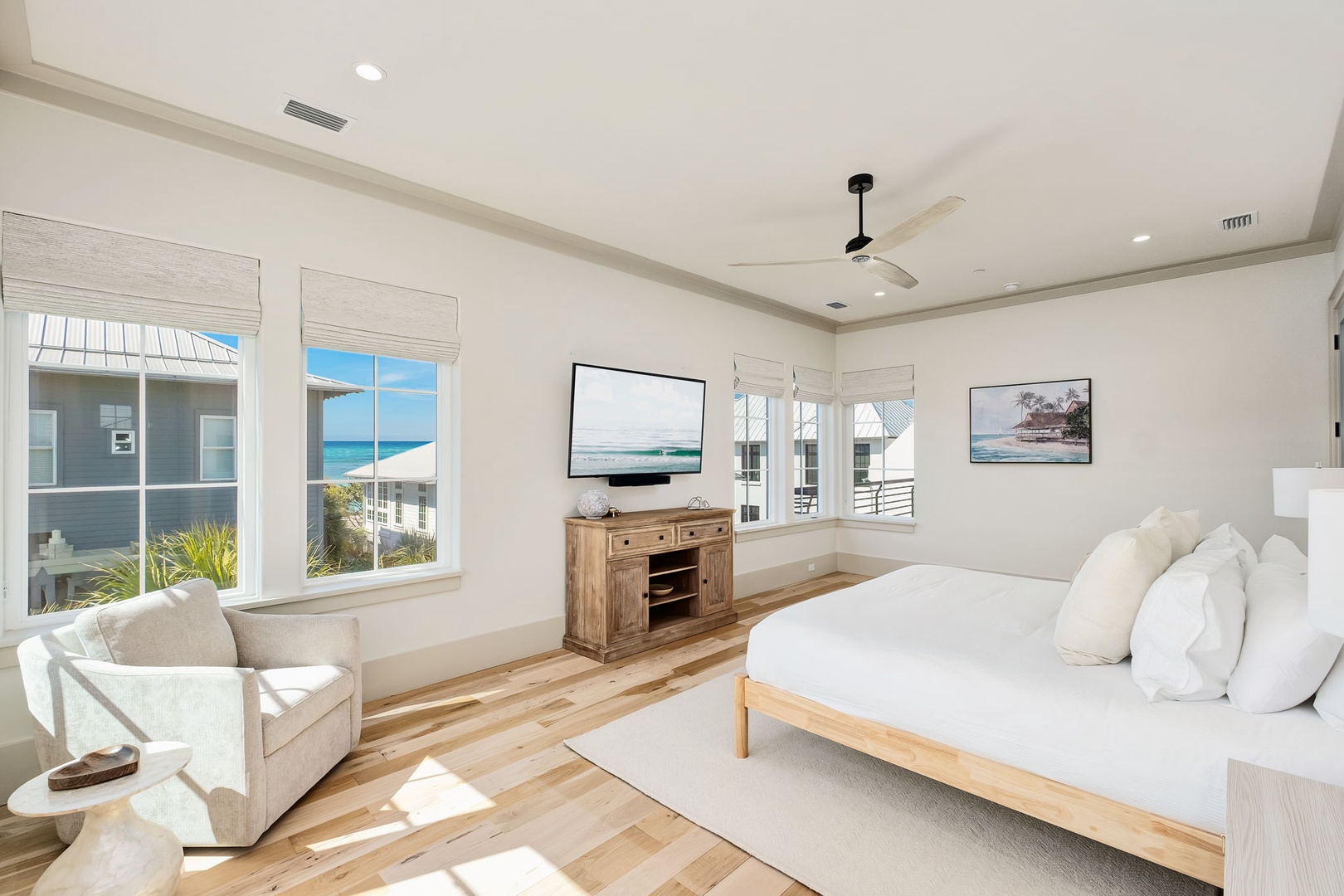 Wake up to breathtaking ocean views in your spacious bedroom, where natural light streams through coastal-inspired windows and gentle ceiling fans keep you comfortable.