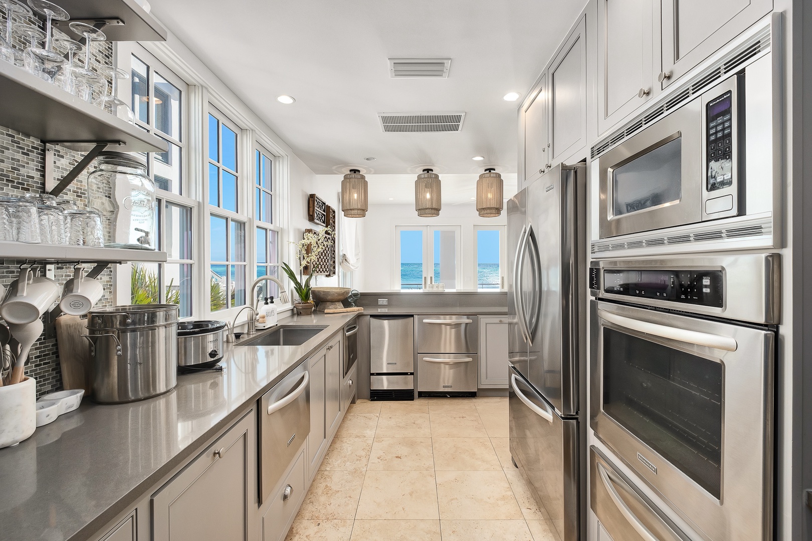 Cook like a chef in this stunning galley kitchen featuring premium stainless steel appliances, gleaming countertops, and ocean views.