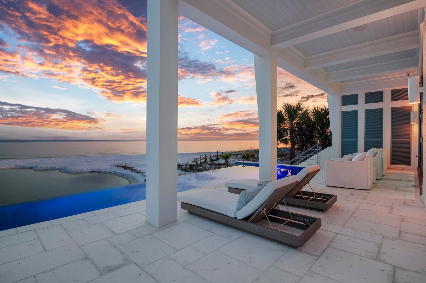 A fiery sunset paints the sky as you lounge by your private pool and soak in sweeping ocean views—the perfect coastal escape to unwind.