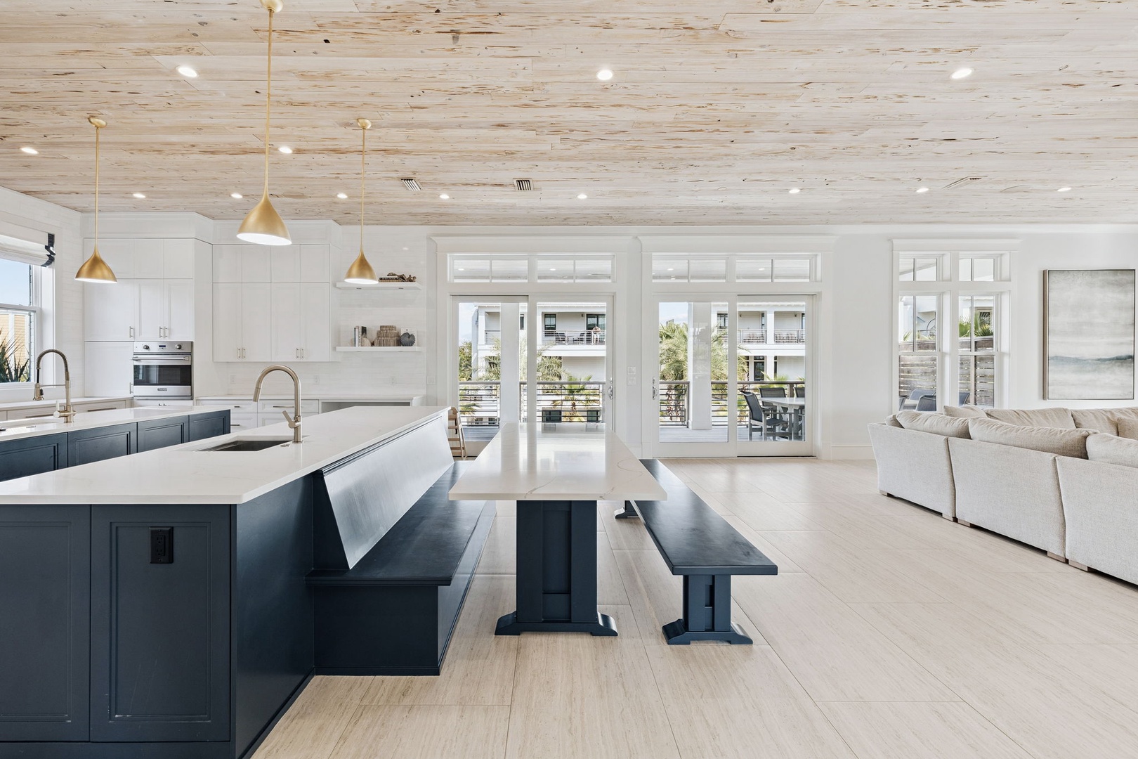 Step into your dream kitchen with sleek navy cabinets, gleaming counters, and warm wood ceilings that create the perfect gathering space.