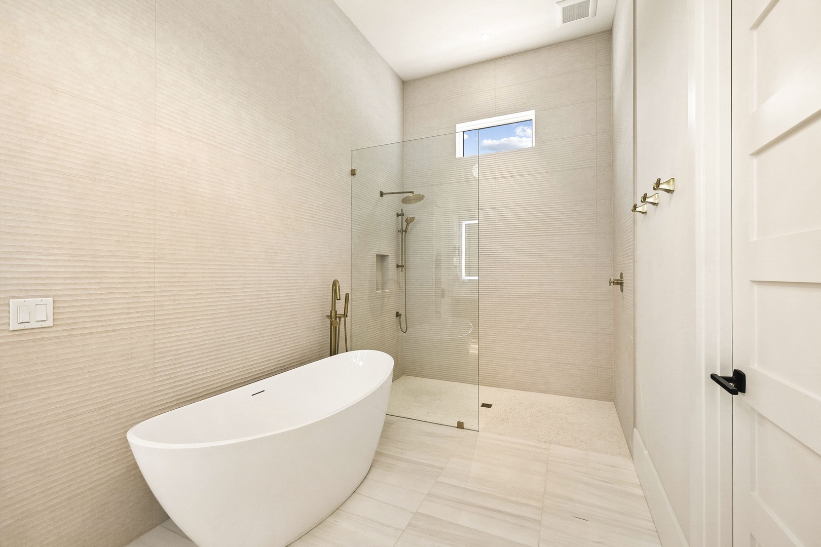 Step into your private spa retreat with a luxurious soaking tub and spacious walk-in shower framed by soft textured tile—pure tranquility awaits.