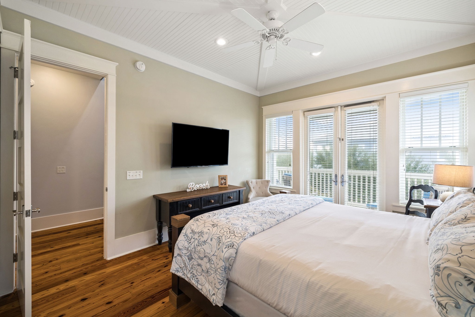 Wake to soft coastal breezes and relax in your serene bedroom retreat with vaulted ceilings, warm hardwood floors, and private deck access for peaceful morning moments.