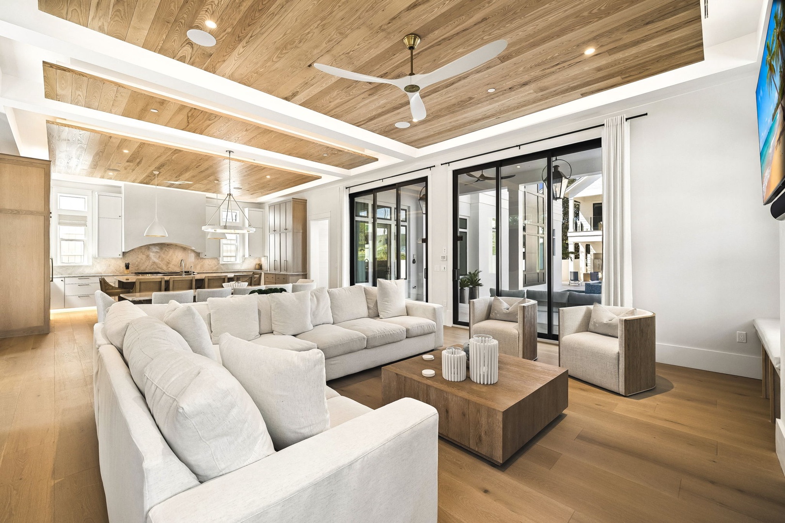 Settle into plush seating under striking wood-paneled ceilings, where your open living space flows effortlessly into the gourmet kitchen—perfect for gathering and unwinding after beach adventures.