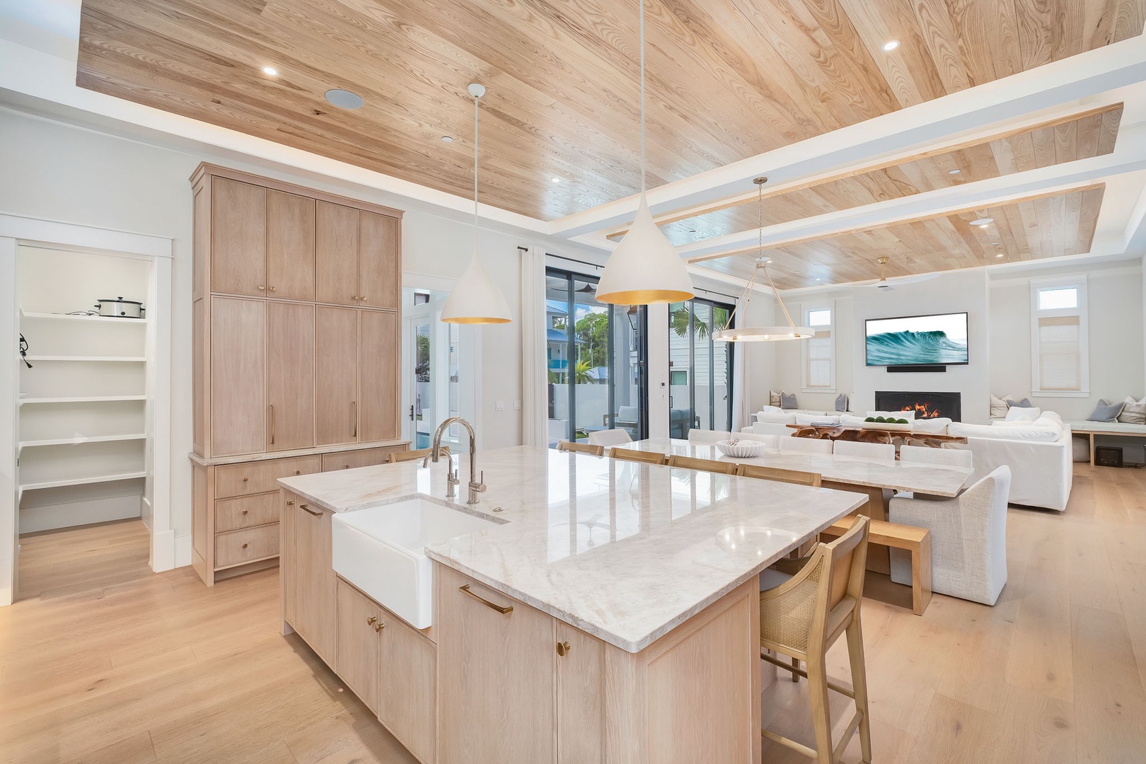 Step into your open-concept haven, where warm wood tones and soaring ceilings create an airy, coastal-modern retreat. The spacious kitchen flows seamlessly into the living area, perfect for gathering and making memories.