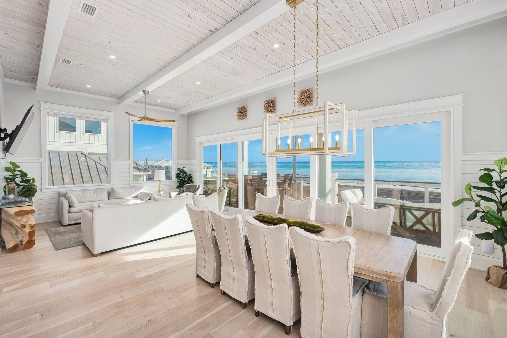 Gather around your elegant dining table while soaking in breathtaking ocean views through expansive windows in this coastal haven.