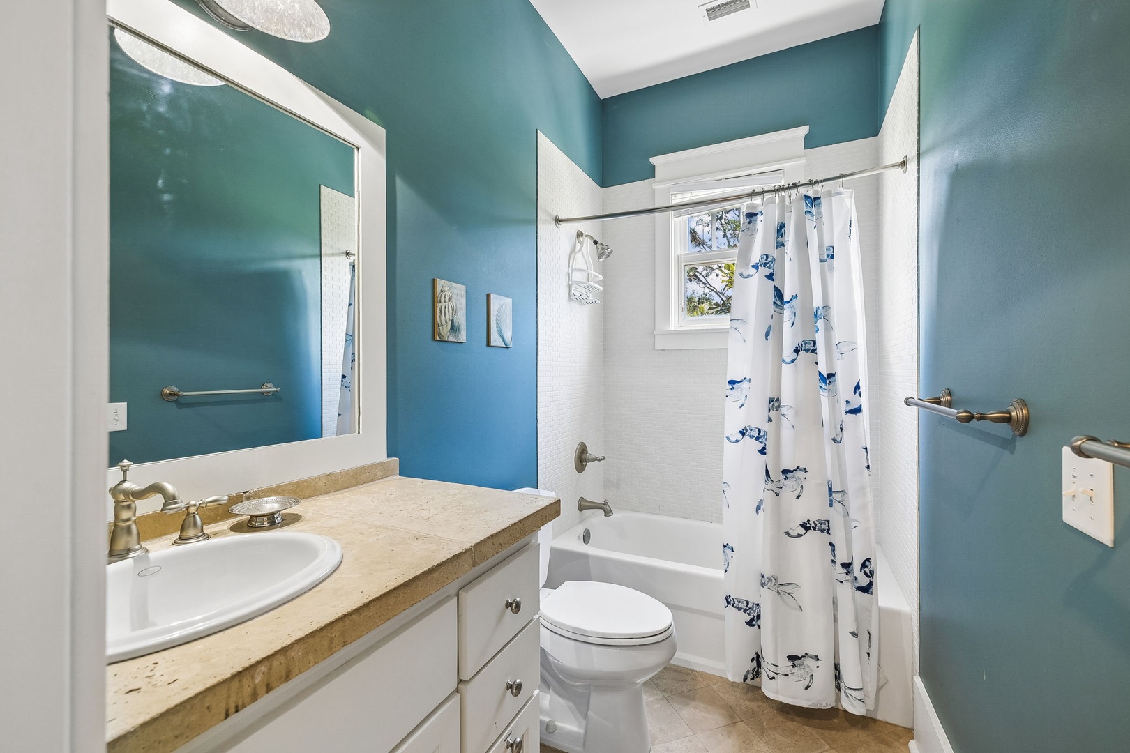 Refresh in your private bathroom with calming teal walls, crisp white tile, and natural light streaming through the window.