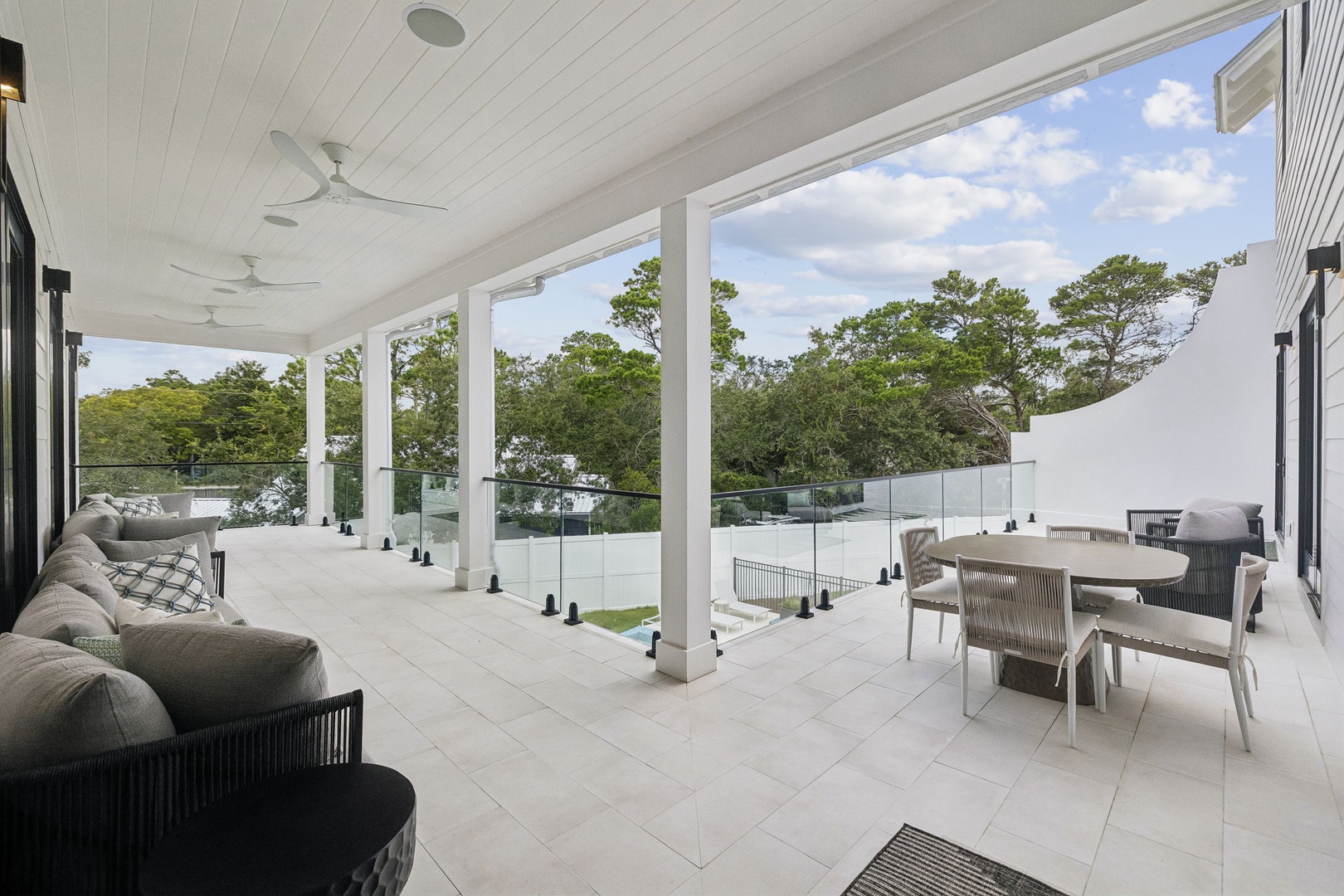 Your spacious covered terrace invites you to unwind with plush seating and dining space overlooking lush greenery—perfect for leisurely mornings or relaxed evenings in the fresh air.