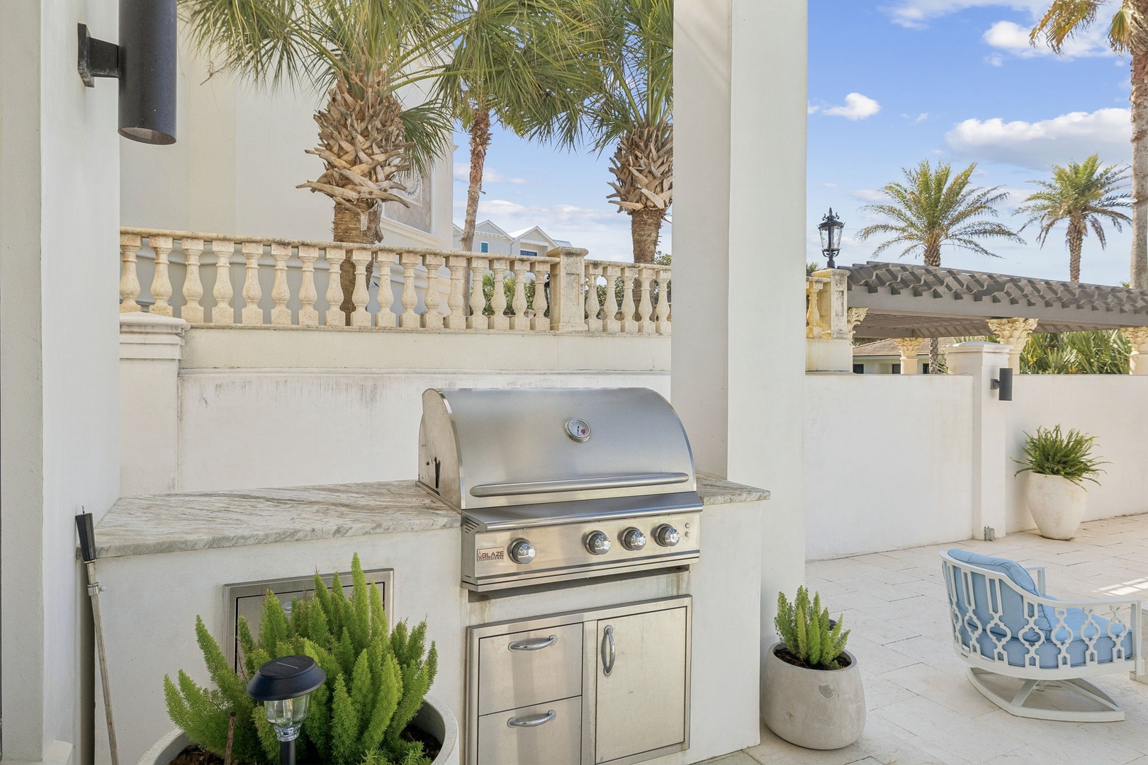 Fire up your culinary creativity at this stunning outdoor kitchen, where palm trees sway overhead and tropical breezes make every meal memorable.