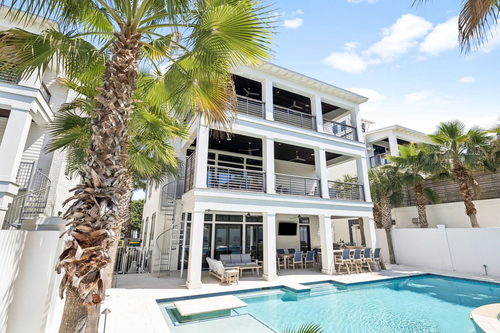A stunning tropical vacation home featuring three levels of modern elegance, complete with private pool and lush palm trees.