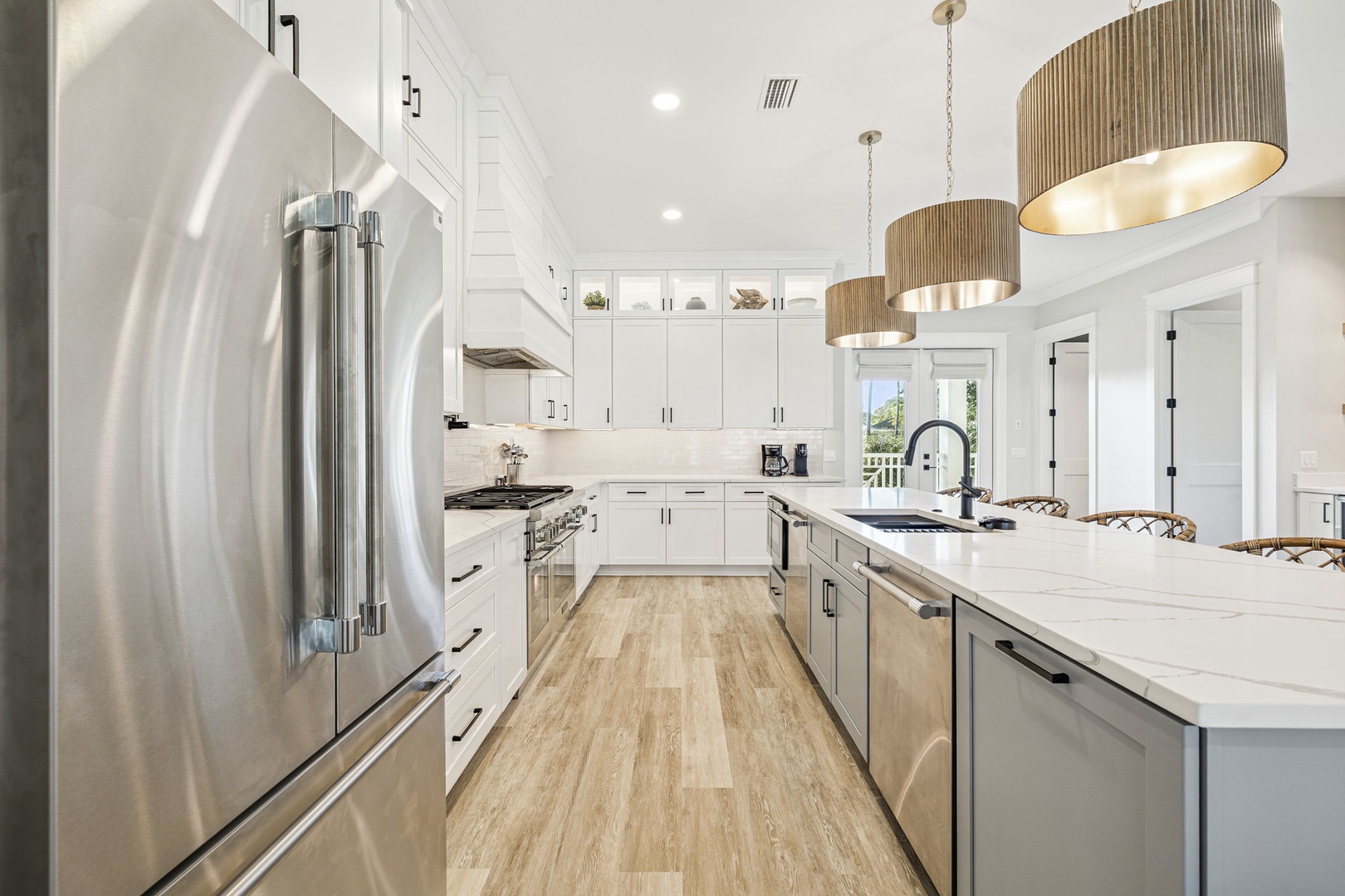 Your fully-equipped kitchen awaits with gleaming stainless steel appliances, marble countertops, and warm pendant lighting creating the perfect cooking experience.