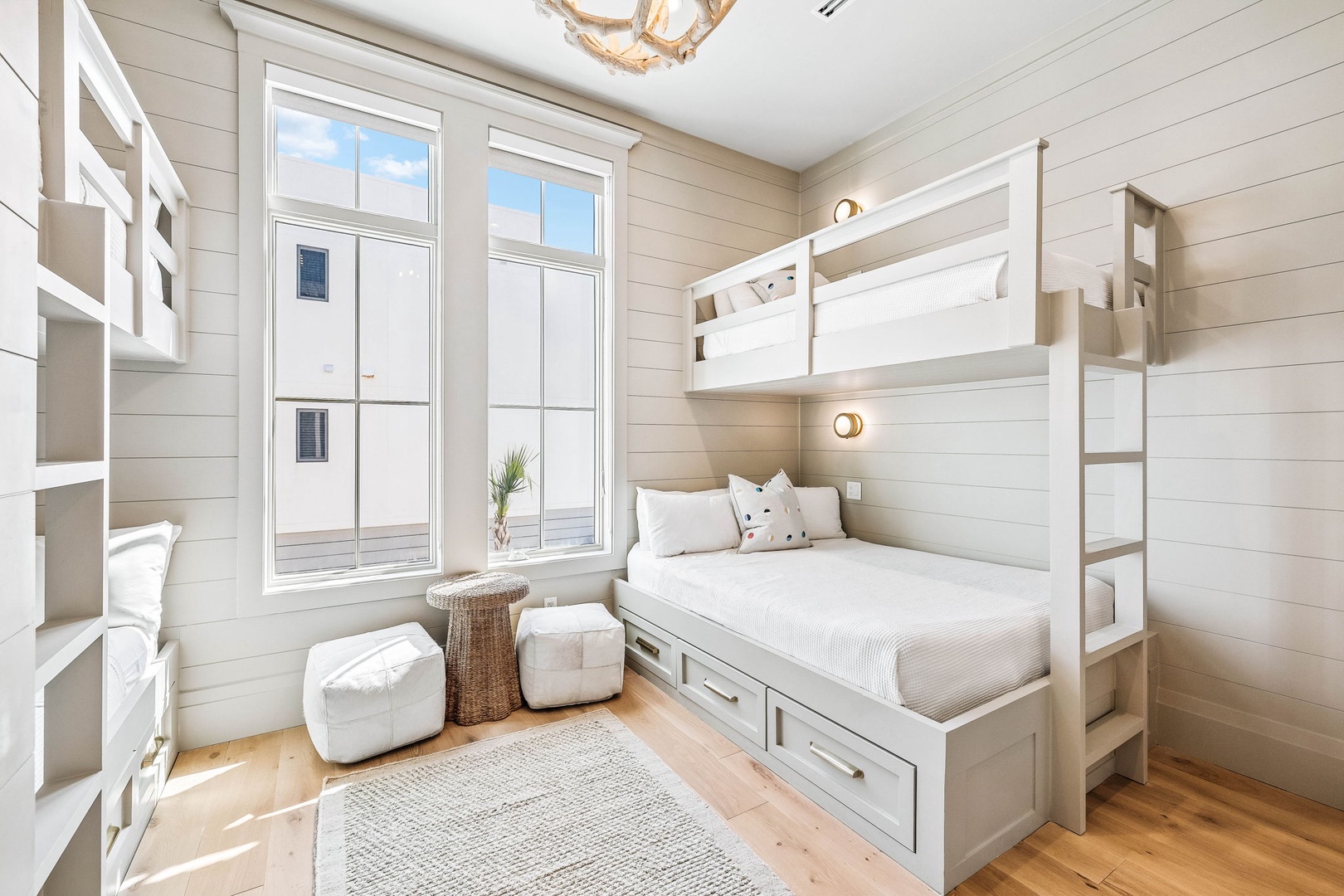 Your coastal-inspired bunk room features custom built-in beds with crisp white linens and cozy storage drawers, perfect for the whole family. Natural light streams through oversized windows, creating a bright and welcoming retreat.