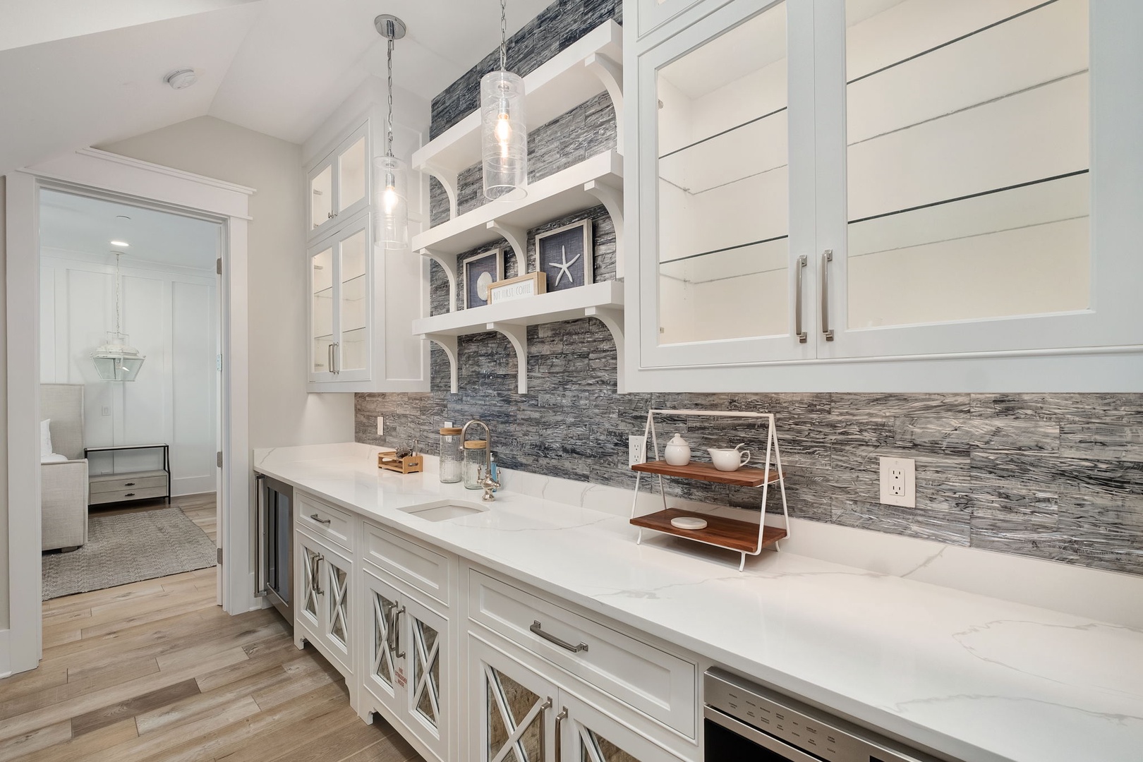 You'll love preparing meals in this gorgeous kitchen with stunning stone backsplash, pristine white cabinetry, and elegant pendant lighting creating the perfect culinary haven.