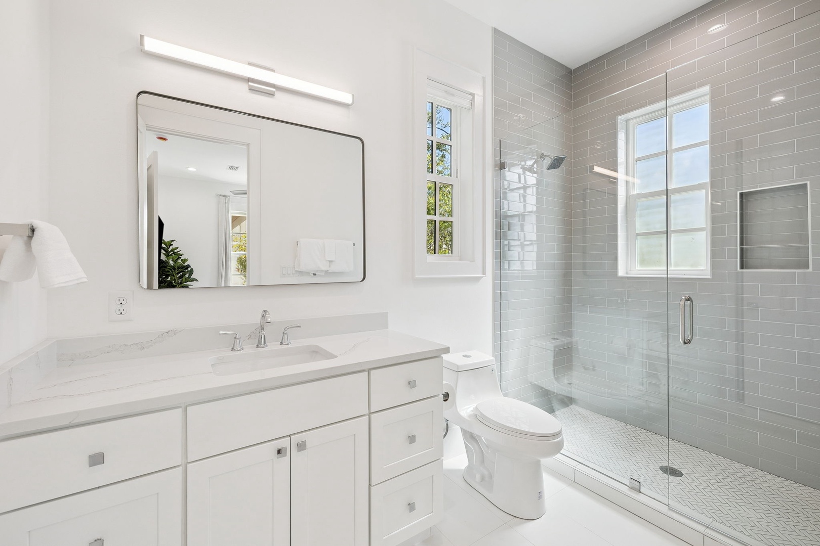 Your elegant bathroom features a luxurious marble vanity and stunning subway-tiled shower with glass doors.