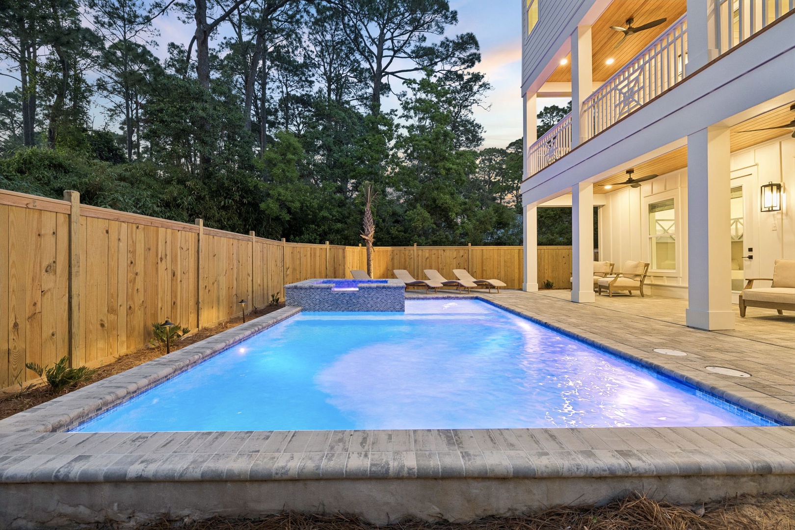 A spacious backyard retreat with private pool and hot tub, surrounded by tall pines. Lounge on your deck, soak in the spa, and unwind in this peaceful wooded haven.
